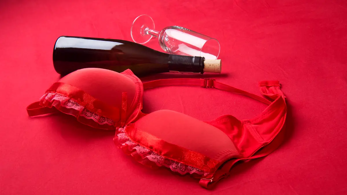 red bra and bottle lying in bed