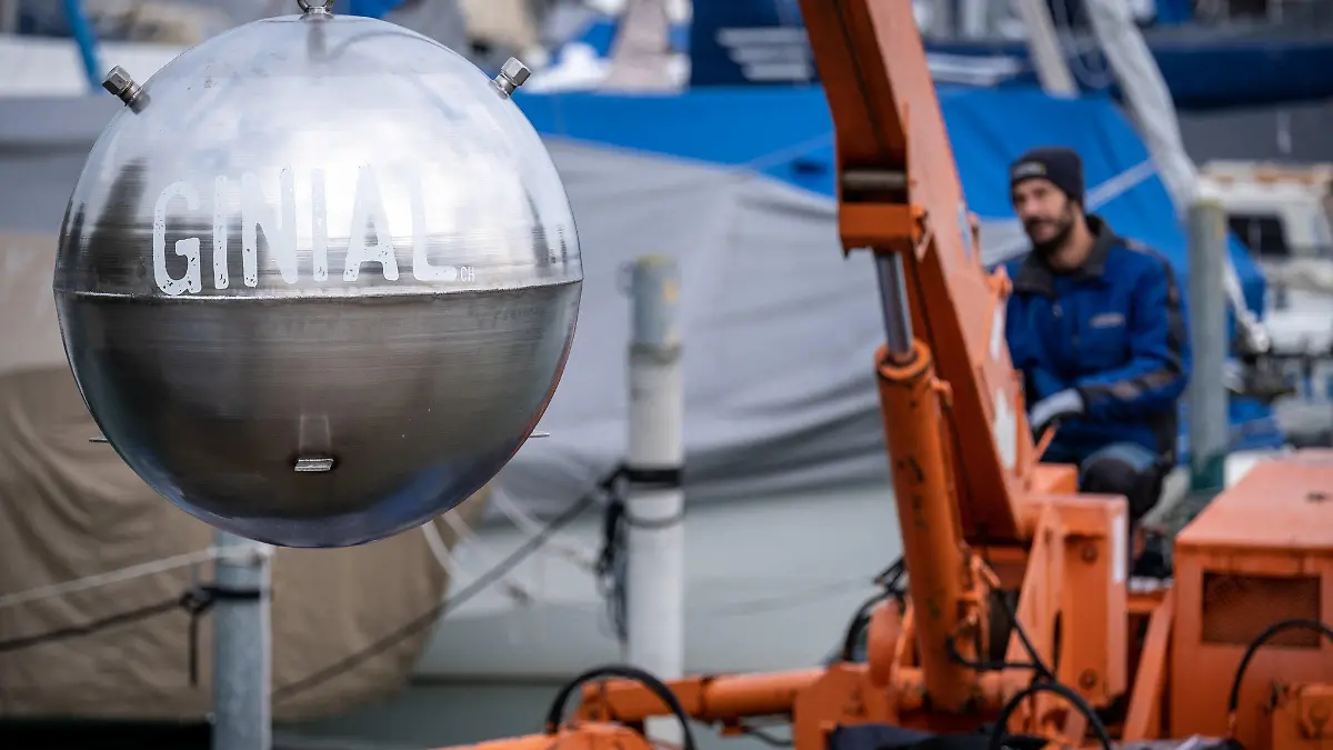HANDOUT - 12.10.2020, Schweiz, Romanshorn: Ein rund 800 Kilogramm schwere Kugel voller Gin wird wird in den Bodensee herabgelassen. Die Besitzer, ein Schweizer Unternehmen für Catering, Eventmanagement, stellt jedes Jahr eine Sonderausgabe Gin her, die 100 Tage lang im See gelagert wird und dadurch ein besonderes Aroma erlangen soll. Als die Kugel im Dezember gehoben werden sollte, fanden Taucher nur noch den Abdruck der Kugel auf dem Seegrund. (zu dpa "Edelstahlkugel mit Gin aus dem Bodensee verschwunden") Foto: Diana Strohmeier/Fishgroup/dpa - ACHTUNG: Nur zur redaktionellen Verwendung im Zusammenhang mit der aktuellen Berichterstattung und nur mit vollständiger Nennung des vorstehenden Credits +++ dpa-Bildfunk +++