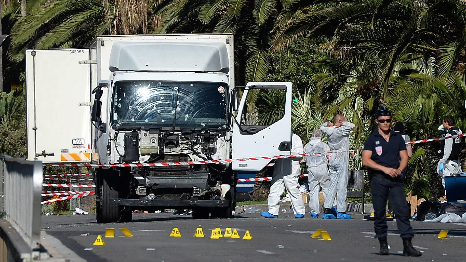 ARCHIV - 15.07.2016, Frankreich, Nizza: Polizisten stehen um den beim Anschlag am Nationalfeiertag benutzten Lastwagen. Sechseinhalb Jahre nach dem wohl islamistisch motivierten Terroranschlag in Nizza mit 86 Toten sollen in Paris die Urteile gegen mutmaßliche Unterstützer des Attentäters fallen. Ihnen wird vorgeworfen, Mitglied in einer terroristischen Vereinigung gewesen zu sein beziehungsweise bei der Beschaffung einer Waffe geholfen zu haben. Die Staatsanwaltschaft forderte für die sieben angeklagten Männer und die angeklagte Frau Strafen zwischen zwei und 15 Jahren Haft sowie teils Landesverbote. Foto: picture alliance/Andreas Gebert/dpa +++ dpa-Bildfunk +++