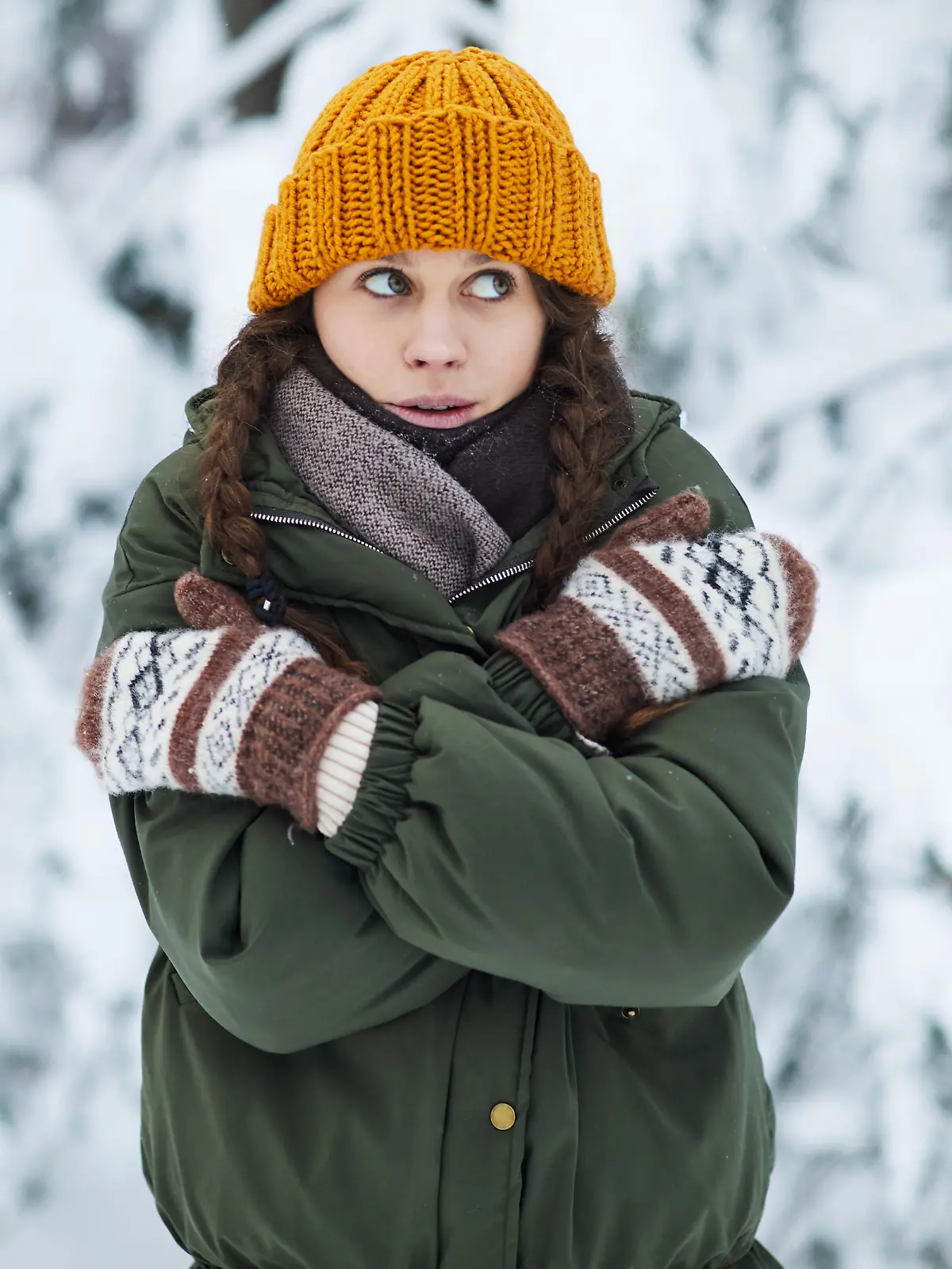 Waist up portrait of pretty young woman freezing in cold winter forest, copy space