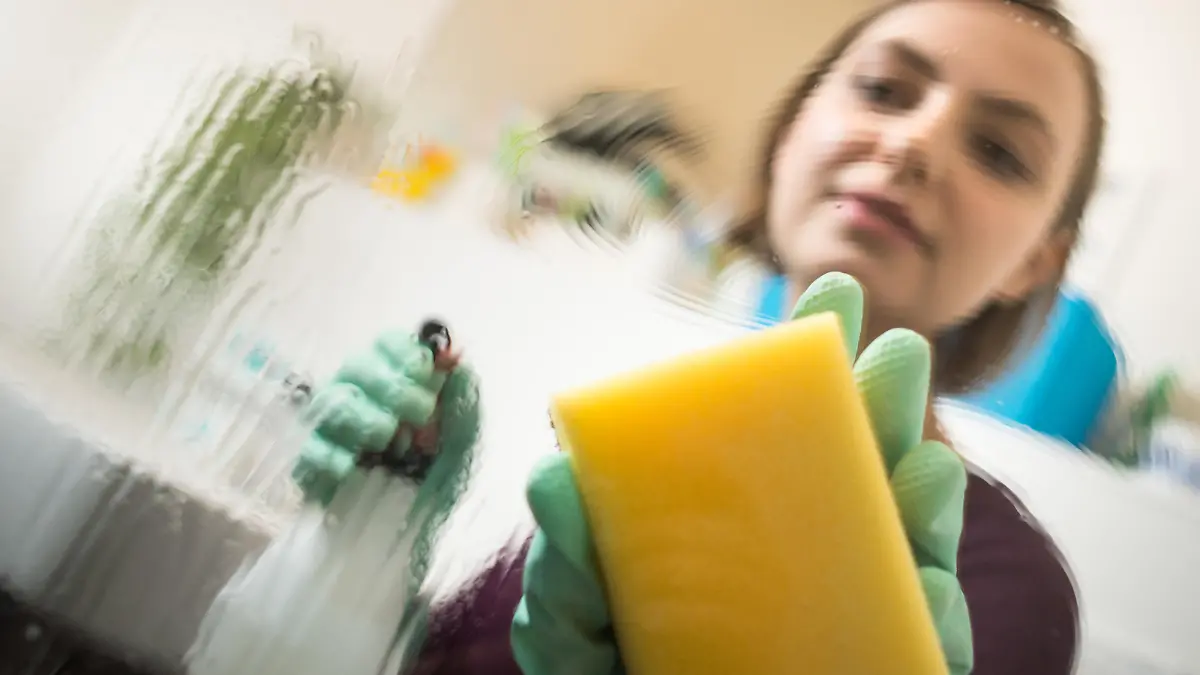 ILLUSTRATION - Eine junge Frau putzt am 09.12.2016 in einem Bad in Berlin die Glaswand der Dusche. Foto: Franziska Gabbert || Modellfreigabe vorhanden