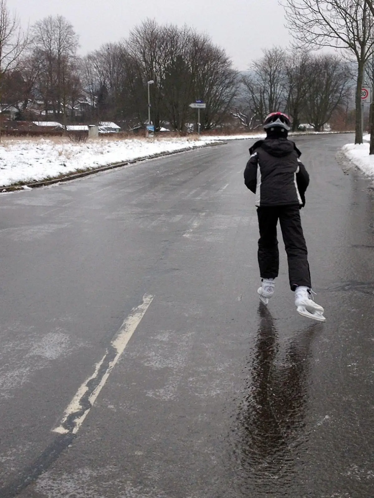 Ein Mann läuft am 20.01.2013 in Karlsruhe (Baden-Württemberg) auf einer komplett vereisten Straße mit Schlittschuhen. Auf den Straßen und Gehwegen in Baden-Württemberg hat am Sonntag Blitzeis für schwierigste Bedingungen gesorgt. Die Streudienste sind pausenlos im Einsatz, vor allem im Norden des Landes ereigneten sich in den Morgenstunden zahlreiche Unfälle. Foto: Susanne Kupke/dpa (zu lsw: "Blitzeis allerorten: Autobahnen im Südwesten teils gesperrt" vom 20.01.2013)  +++(c) dpa - Bildfunk+++