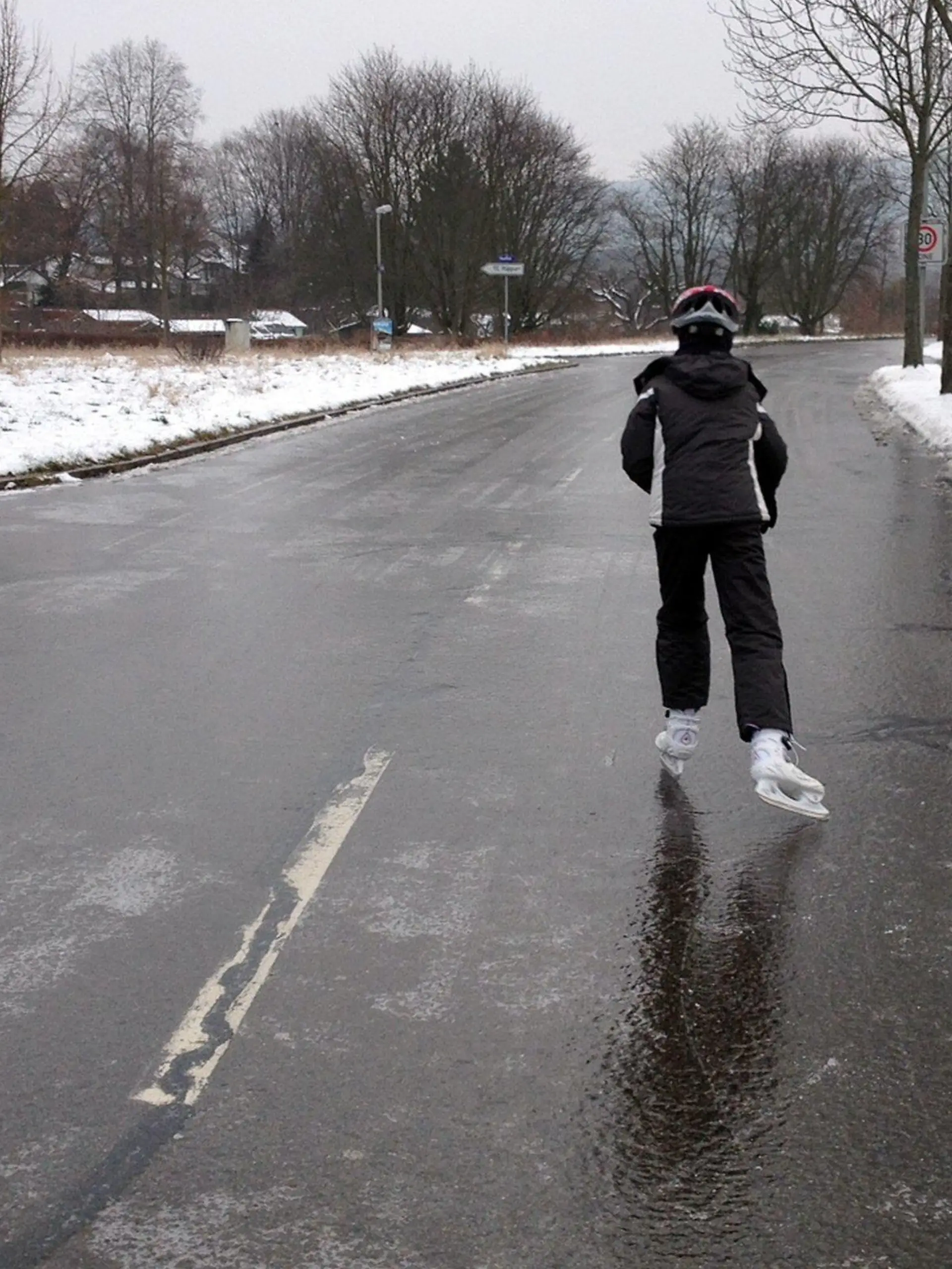 Ein Mann läuft am 20.01.2013 in Karlsruhe (Baden-Württemberg) auf einer komplett vereisten Straße mit Schlittschuhen. Auf den Straßen und Gehwegen in Baden-Württemberg hat am Sonntag Blitzeis für schwierigste Bedingungen gesorgt. Die Streudienste sind pausenlos im Einsatz, vor allem im Norden des Landes ereigneten sich in den Morgenstunden zahlreiche Unfälle. Foto: Susanne Kupke/dpa (zu lsw: "Blitzeis allerorten: Autobahnen im Südwesten teils gesperrt" vom 20.01.2013)  +++(c) dpa - Bildfunk+++