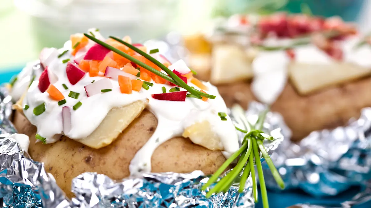 Baked potatoe with sour cream, radishes, carrots and chives