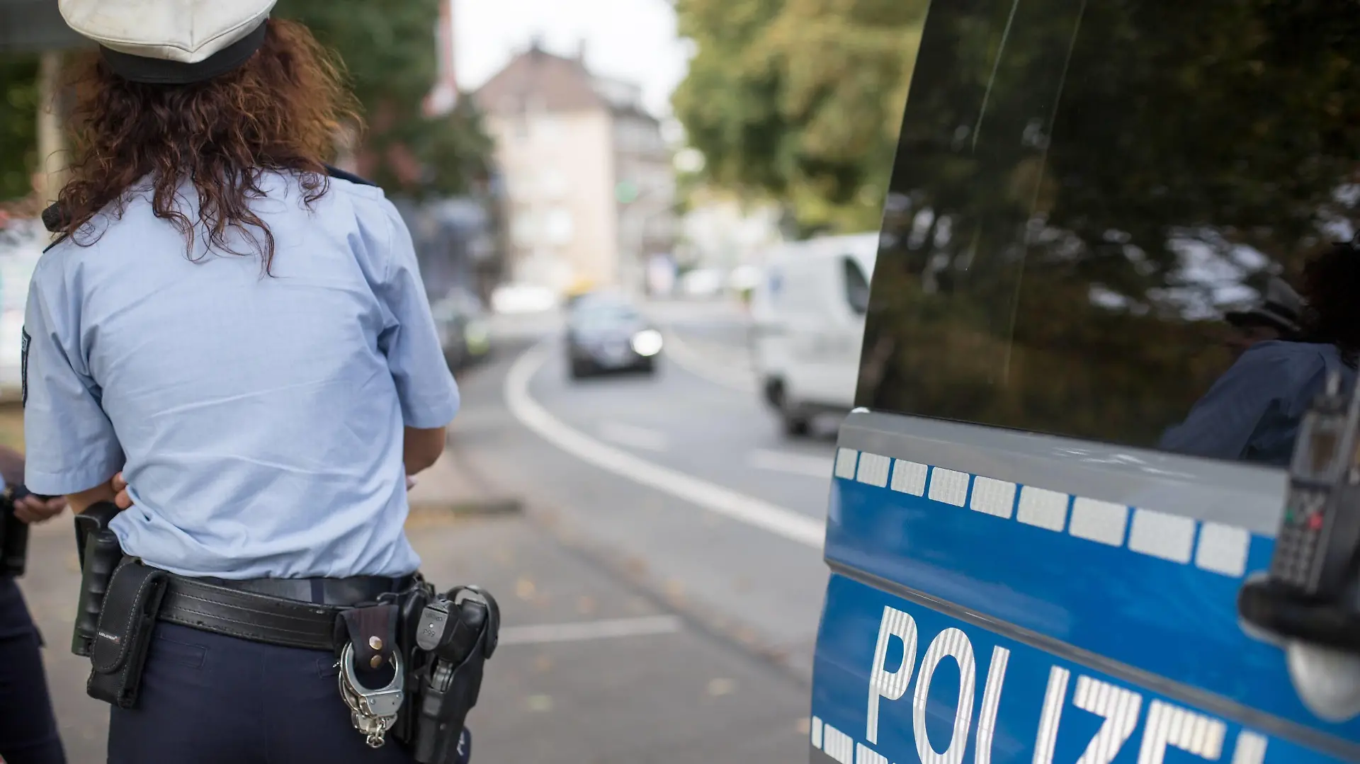 Polizistin neben ihrem Streifenwagen mit dem Schriftzug Polizei und vorbeifahrenden Autos Länderübergreifende Verkehrssicherheitsaktion sicher.mobil.leben, Pressetermin Solingen, 20.09.18 Solingen NRW Deutschland Birker Straße / Südpark *** Policewoman next to her patrol car with the lettering Police and passing cars Cross-border traffic safety campaign safe mobile life Press Conference Solingen 20 09 18 Solingen NRW Germany Birker Straße Südpark Copyright: xdnet_cdnx
