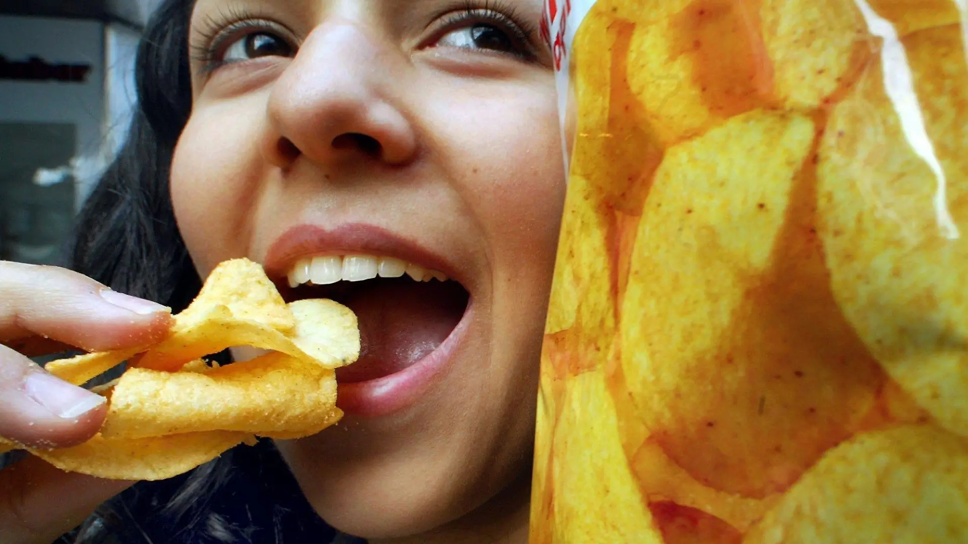 Eine junge Frau isst Kartoffelchips (Symbolbild aufgenommen am 4.12.2002 in Düsseldorf). Der Anteil des Krebs erregenden Stoffes Acrylamid ist in einigen Lebensmitteln nach Angaben des Verbraucherschutzministeriums gesunken. So sei es etwa bei Chips oder Knäckebrot gelungen, Acrylamidgehalte zu verringern. In ganz Deutschland seien rund 1000 Lebensmittelproben, vor allem Pommes frites, Bratkartoffeln, Chips und Getreideprodukte wie Kekse oder Knäckebrot, getestet worden. Acrylamid entsteht beim Backen, Rösten und Braten stärkehaltiger Lebensmittel. Nach den Worten der Bundesministerin für Verbraucherschutz, Künast (Grüne), kann der Anteil von Acrylamid in der Nahrung durch die Art der Zubereitung rapide reduziert werden.