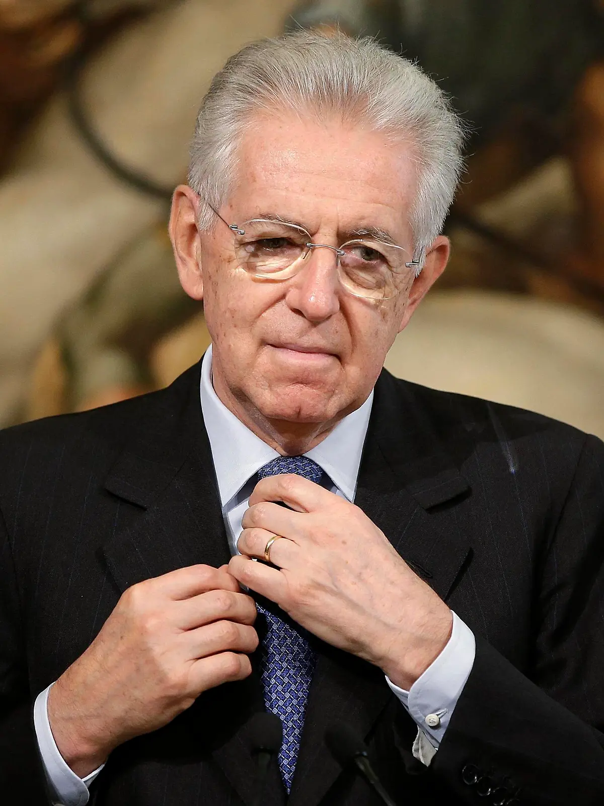 Italy's Prime Minister Mario Monti adjusts his tie during a joint news conference with Austria's Chancellor Werner Faymann at Chigi Palace in Rome, in this October 24, 2012 file picture. Monti on December 21, 2012 resigned as Italy's Prime Minister, opening the way to elections expected in February. REUTERS/Tony Gentile/Files (ITALY - Tags: POLITICS)