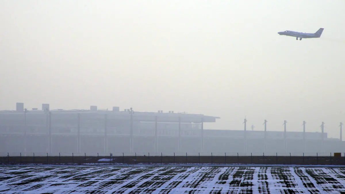 Ein startendes Flugzeug fliegt am 18.12.2012 über das Terminal des neuen Flughafen Berlin Brandenburg Willy Brandt (BER) in Schönefeld (Brandenburg) bei Berlin. Technikchef Amann berät am Dienstag mit Vertretern der Unternehmen Siemens und Bosch über die Probleme mit der Brandschutzanlage. Foto: Bernd Settnik dpa Foto: Bernd Settnik dpa  +++(c) dpa - Bildfunk+++
