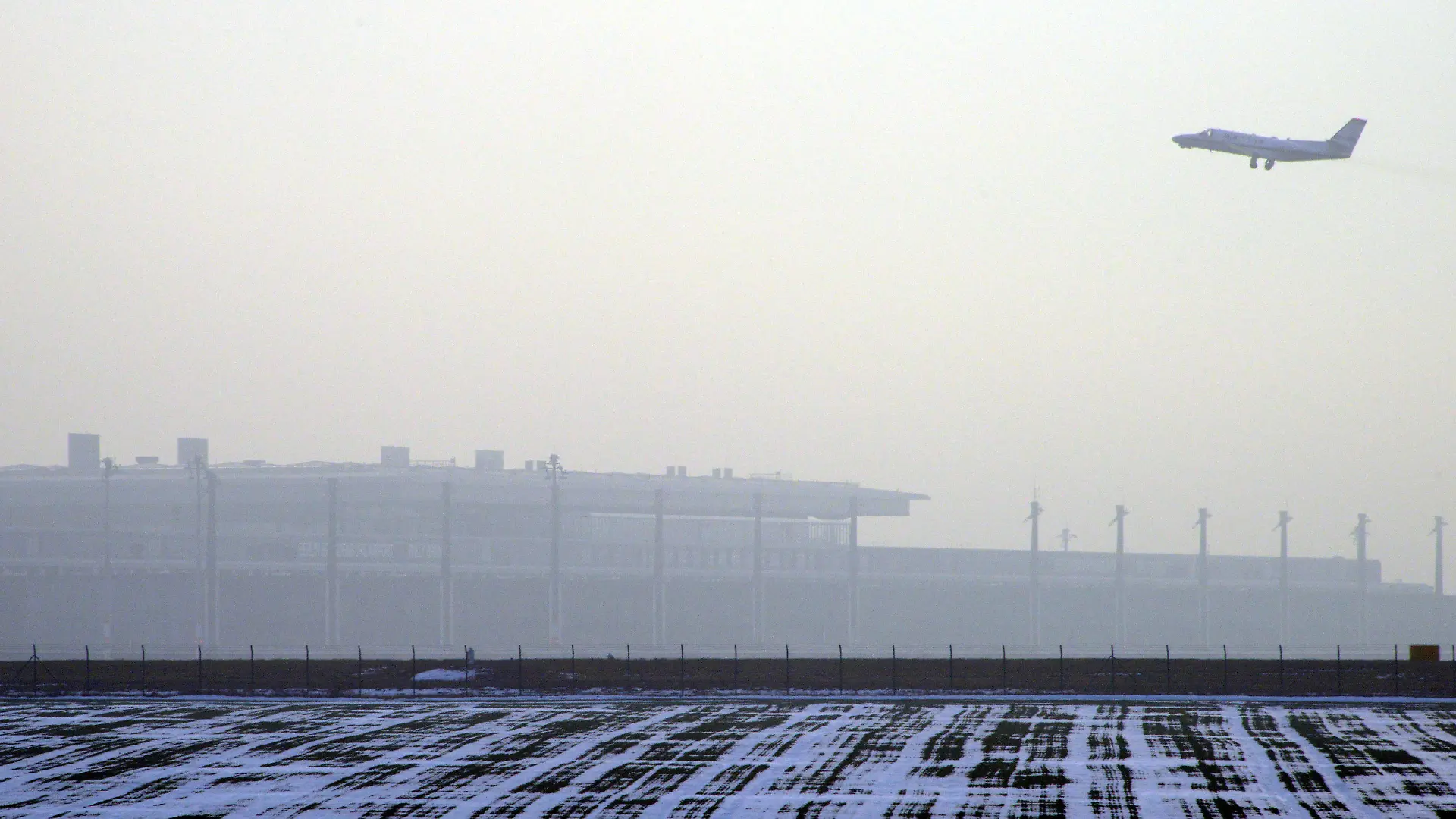 Ein startendes Flugzeug fliegt am 18.12.2012 über das Terminal des neuen Flughafen Berlin Brandenburg Willy Brandt (BER) in Schönefeld (Brandenburg) bei Berlin. Technikchef Amann berät am Dienstag mit Vertretern der Unternehmen Siemens und Bosch über die Probleme mit der Brandschutzanlage. Foto: Bernd Settnik dpa Foto: Bernd Settnik dpa +++(c) dpa - Bildfunk+++