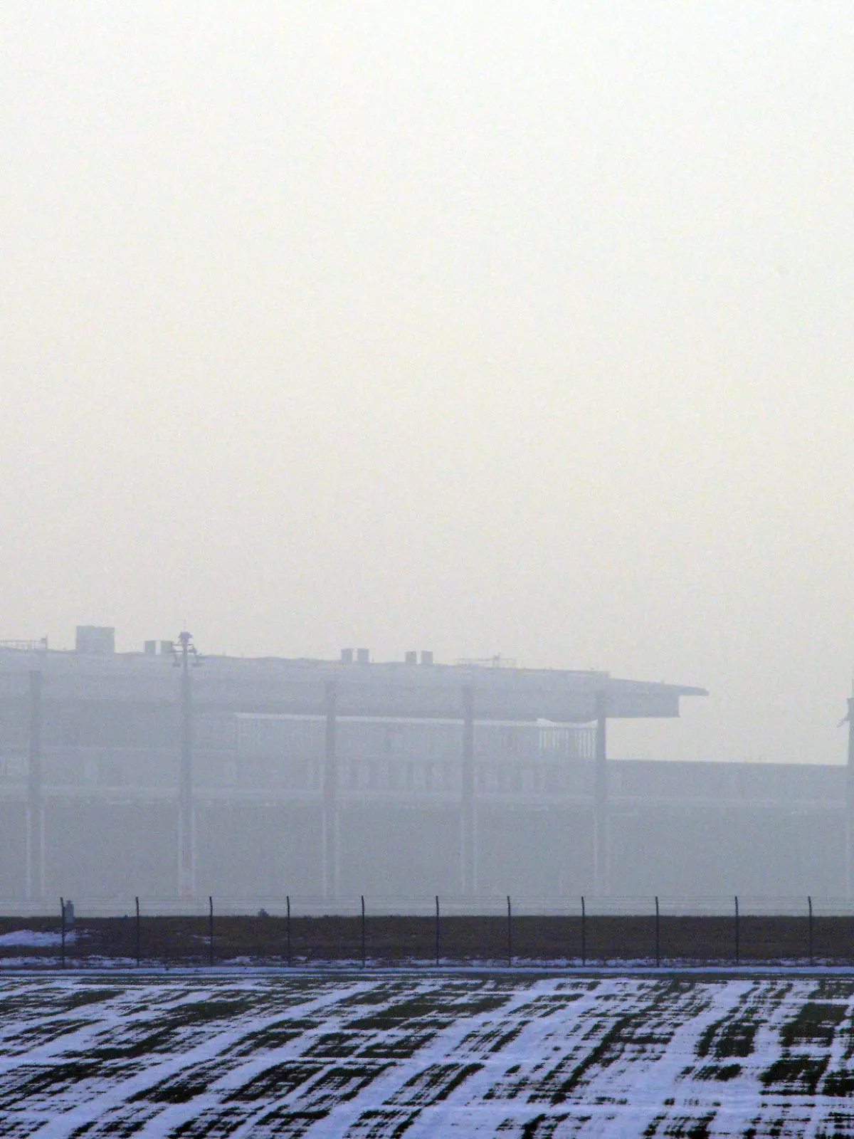 Ein startendes Flugzeug fliegt am 18.12.2012 über das Terminal des neuen Flughafen Berlin Brandenburg Willy Brandt (BER) in Schönefeld (Brandenburg) bei Berlin. Technikchef Amann berät am Dienstag mit Vertretern der Unternehmen Siemens und Bosch über die Probleme mit der Brandschutzanlage. Foto: Bernd Settnik dpa Foto: Bernd Settnik dpa  +++(c) dpa - Bildfunk+++