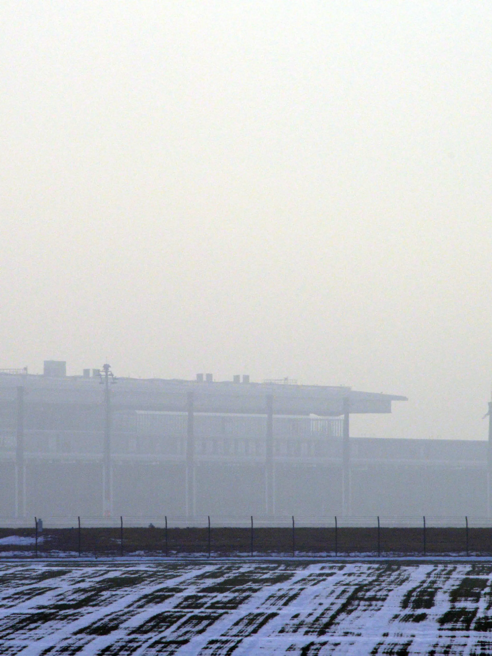 Ein startendes Flugzeug fliegt am 18.12.2012 über das Terminal des neuen Flughafen Berlin Brandenburg Willy Brandt (BER) in Schönefeld (Brandenburg) bei Berlin. Technikchef Amann berät am Dienstag mit Vertretern der Unternehmen Siemens und Bosch über die Probleme mit der Brandschutzanlage. Foto: Bernd Settnik dpa Foto: Bernd Settnik dpa  +++(c) dpa - Bildfunk+++