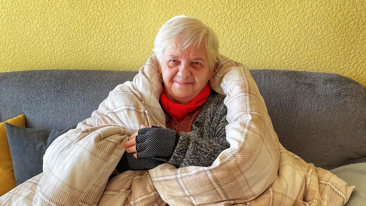 Mieterin mit Decke auf dem Sofa