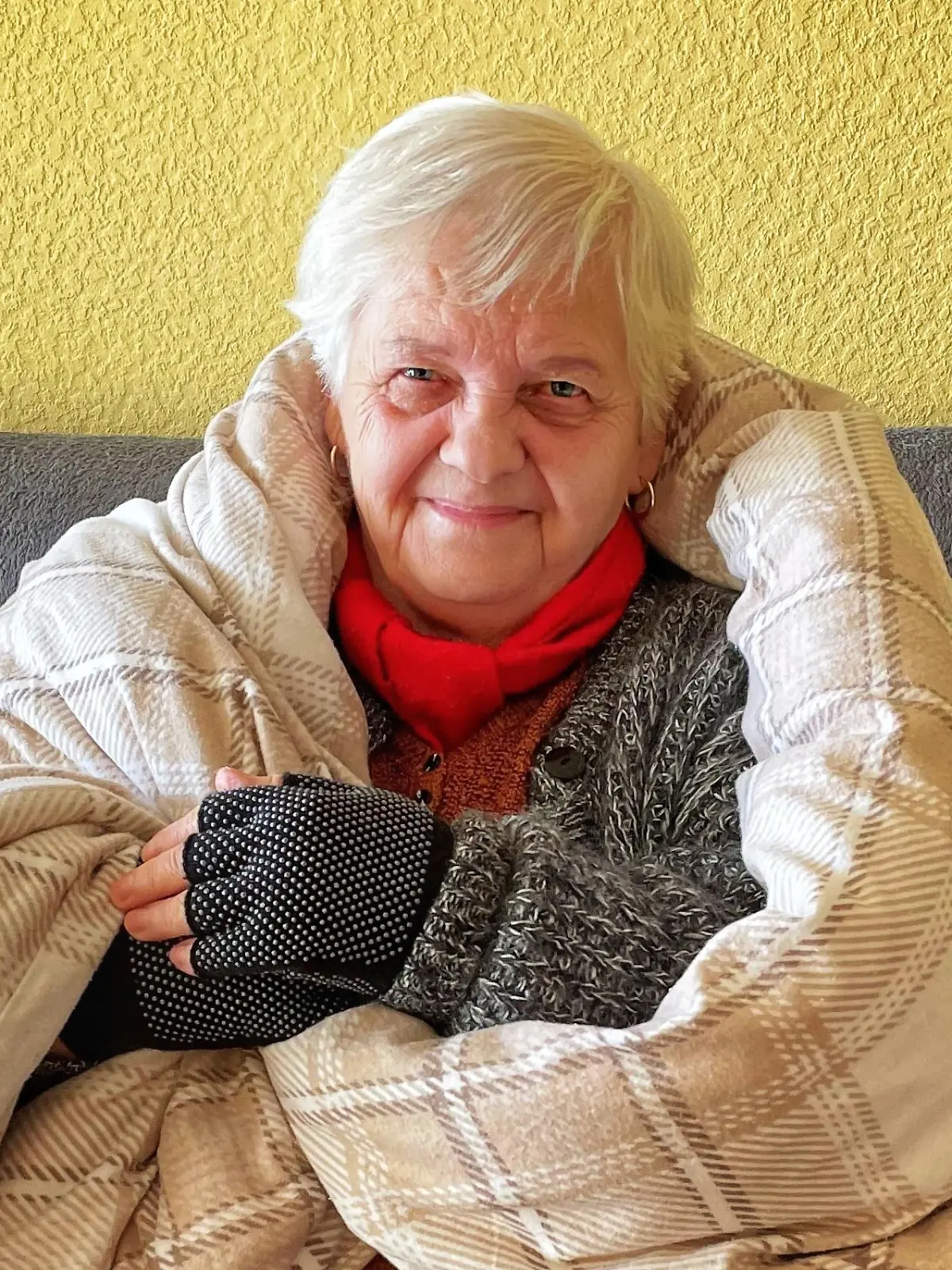 Mieterin mit Decke auf dem Sofa