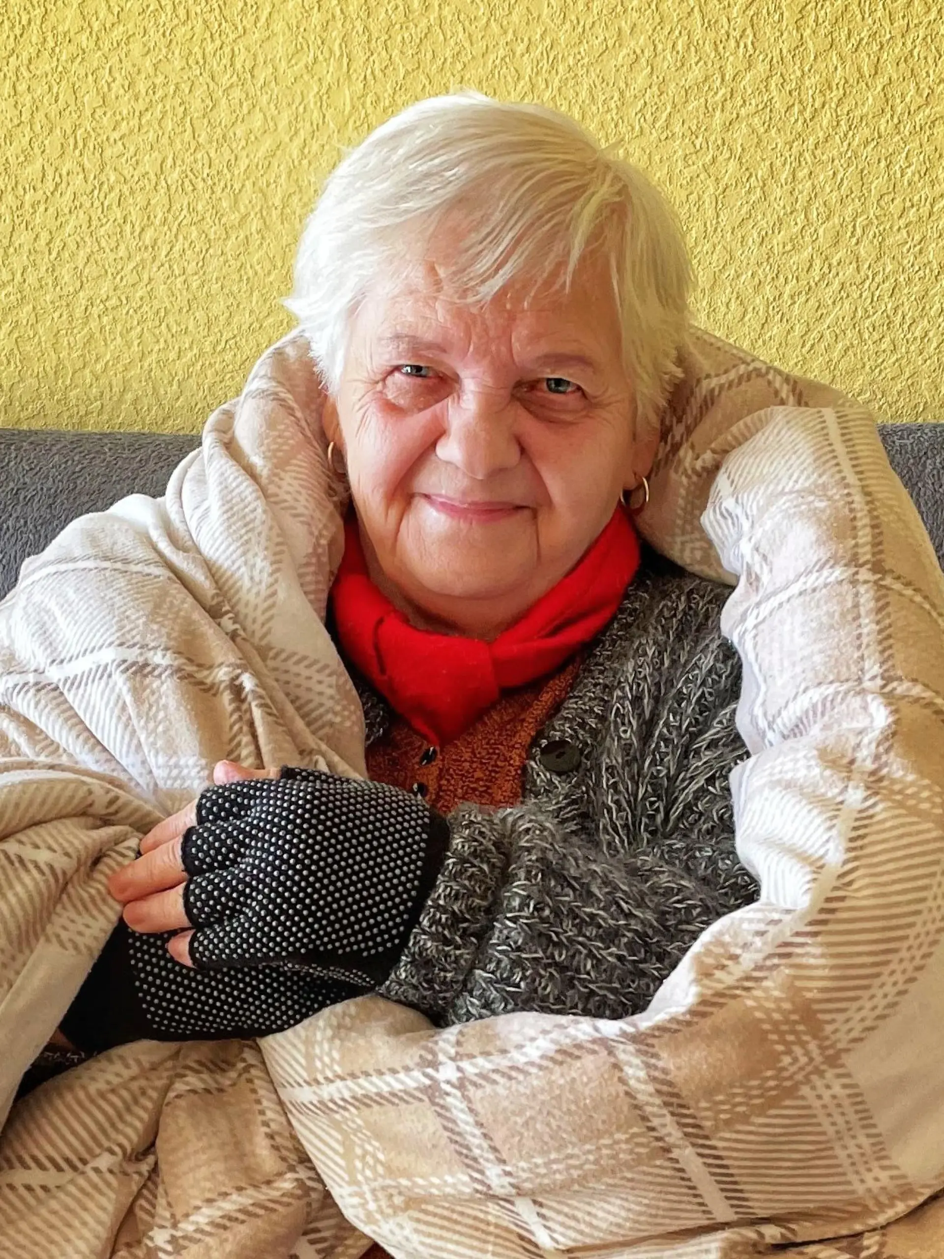 Mieterin mit Decke auf dem Sofa