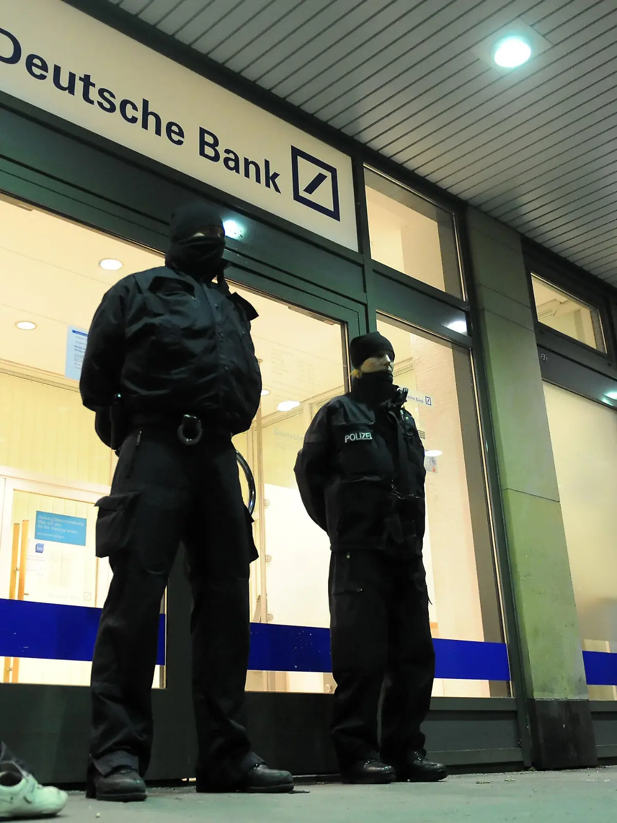 Nach einer unblutig beendeten Geiselnahme stehen Einsatzkräfte der Polizei vor der Bankfiliale am 22.12.2012 im Stadtteil Zehlendorf in Berlin. Ein Bankräuber hatte bei einem Überfall auf die Bank einen Angestellten als Geisel genommen. Foto: Britta Pedersen/dpa  +++(c) dpa - Bildfunk+++