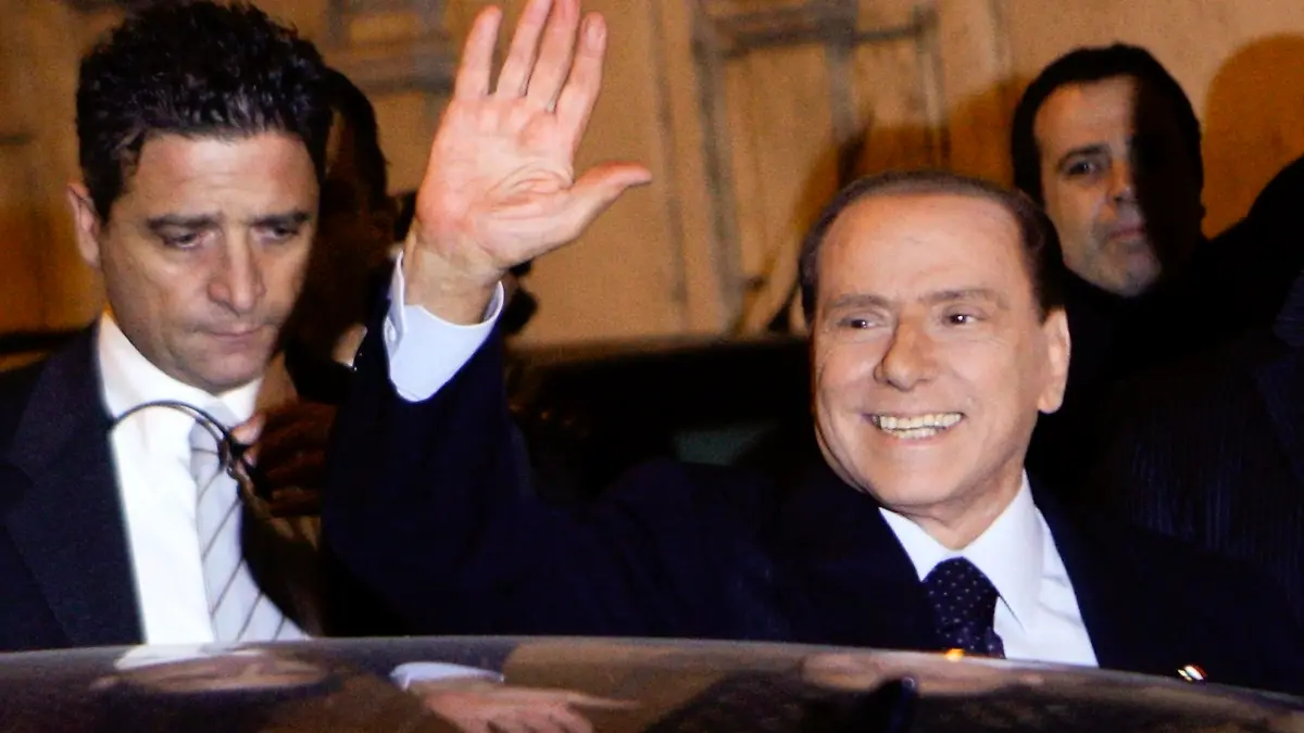 Former Italian Prime Minister Silvio Berlusconi waves as he leaves his residence in downtown Rome November 13, 2011. President Giorgio Napolitano is expected to ask former European Commissioner Mario Monti to try to form a government of technocrats in time for the opening of markets on Monday. REUTERS/Remo Casilli (ITALY - Tags: POLITICS)