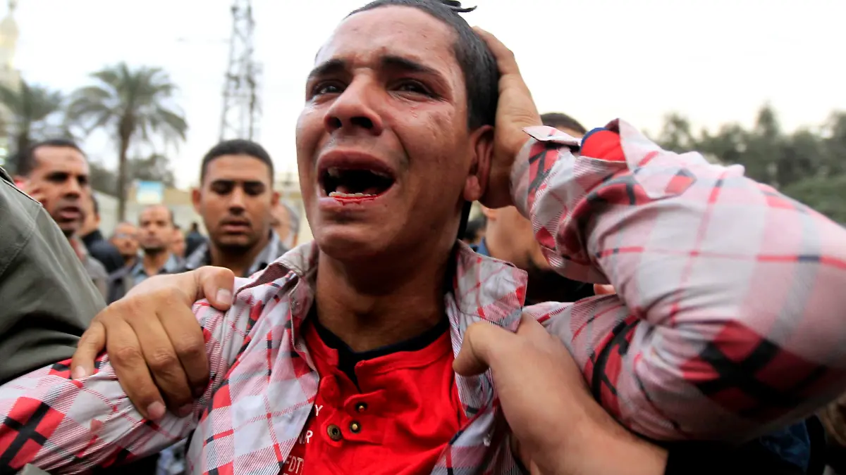 An anti-Mursi protester reacts after being hit by supporters of Egypt's President Mohammed Mursi and members of the Muslim Brotherhood during clashes outside the presidential palace in Cairo December 5, 2012. Islamists fought protesters outside the Egyptian president's palace on Wednesday, while inside the building his deputy proposed a way to end a crisis over a draft constitution that has split the most populous Arab nation. REUTERS/Mohamed Abd El Ghany (EGYPT - Tags: POLITICS CIVIL UNREST)