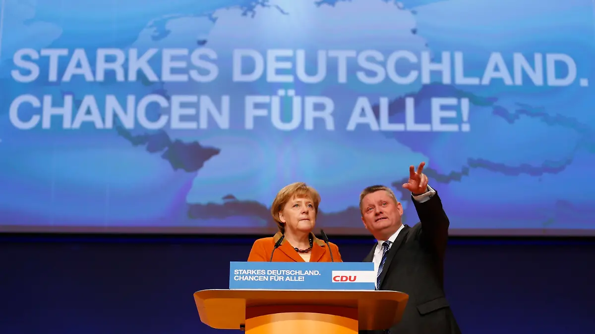 German Chancellor and leader of Germany's Christian Democratic Union (CDU), Angela Merkel (L ) and party general secretary Hermann Groehe inspect the convention hall one day ahead of the CDU's annual party meeting in Hanover, December 3, 2012. 1001 delegates are expected to elect party leader and German Chancellor Angela Merkel as top candidate for Germany's 2013 general elections during the three day party convention.  REUTERS/Kai Pfaffenbach (GERMANY - Tags: POLITICS)