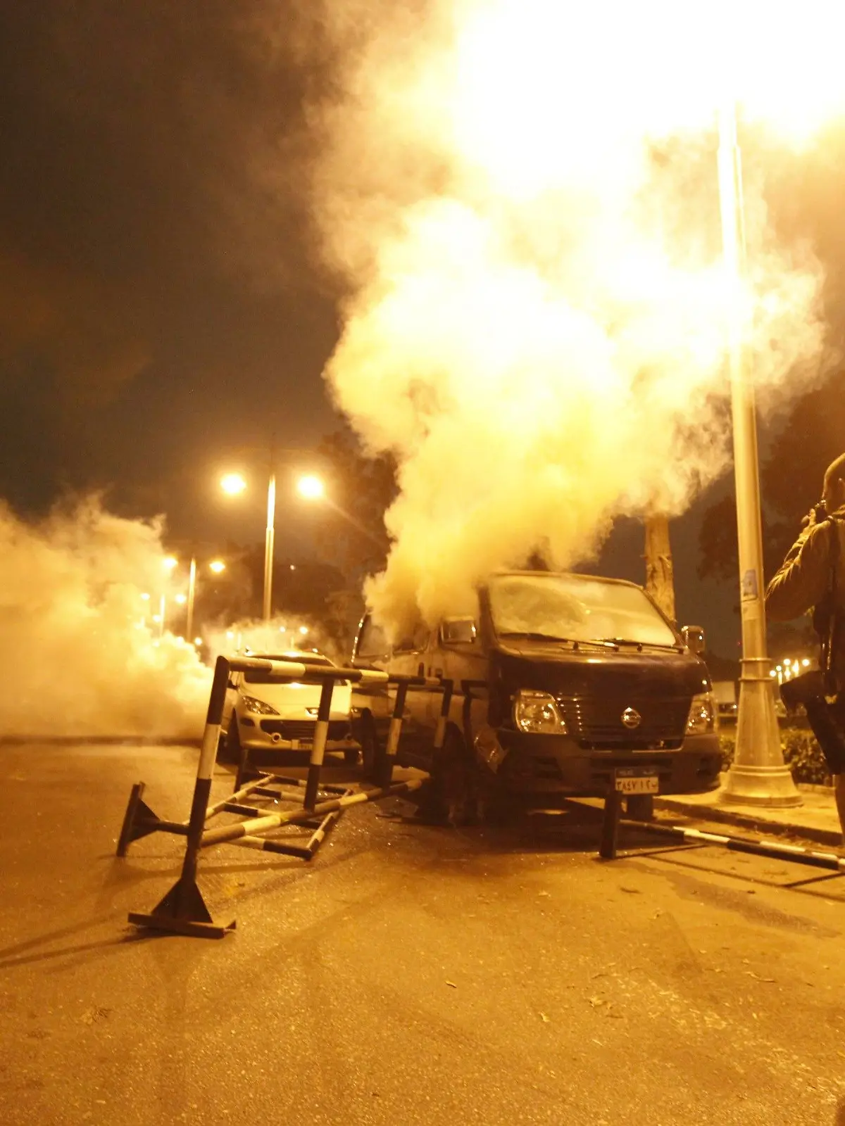 An anti-Mursi protester takes a photo of a riot police van with tear gas smoke coming out of it during clashes in front of the presidential palace in Cairo, December 4, 2012. Egyptian police battled thousands of protesters outside President Mohamed Mursi's palace in Cairo on Tuesday, prompting the Islamist leader to leave the building, two presidential sources said. REUTERS/Amr Abdallah Dalsh  (EGYPT - Tags: POLITICS CIVIL UNREST)