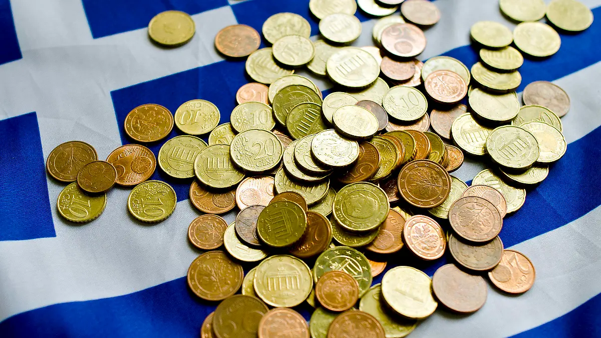 Illustration: Auf einer Griechenland-Fahne liegen Münzen, aufgenommen am Mittwoch (22.06.2011) in einem Griechischen Restaurant in Dresden. Der drohende Finanzkollaps in Griechenland wird zu Debatten der EU-Staats- und Regierungschefs bei ihrem am Donnerstagabend (23.06.2011) in Brüssel beginnenden Gipfeltreffen führen. Entscheidungen zu neuen Hilfen sind aber laut Einladungsschreiben nicht geplant. Foto: Arno Burgi dpa/lsn +++(c) dpa - Bildfunk+++