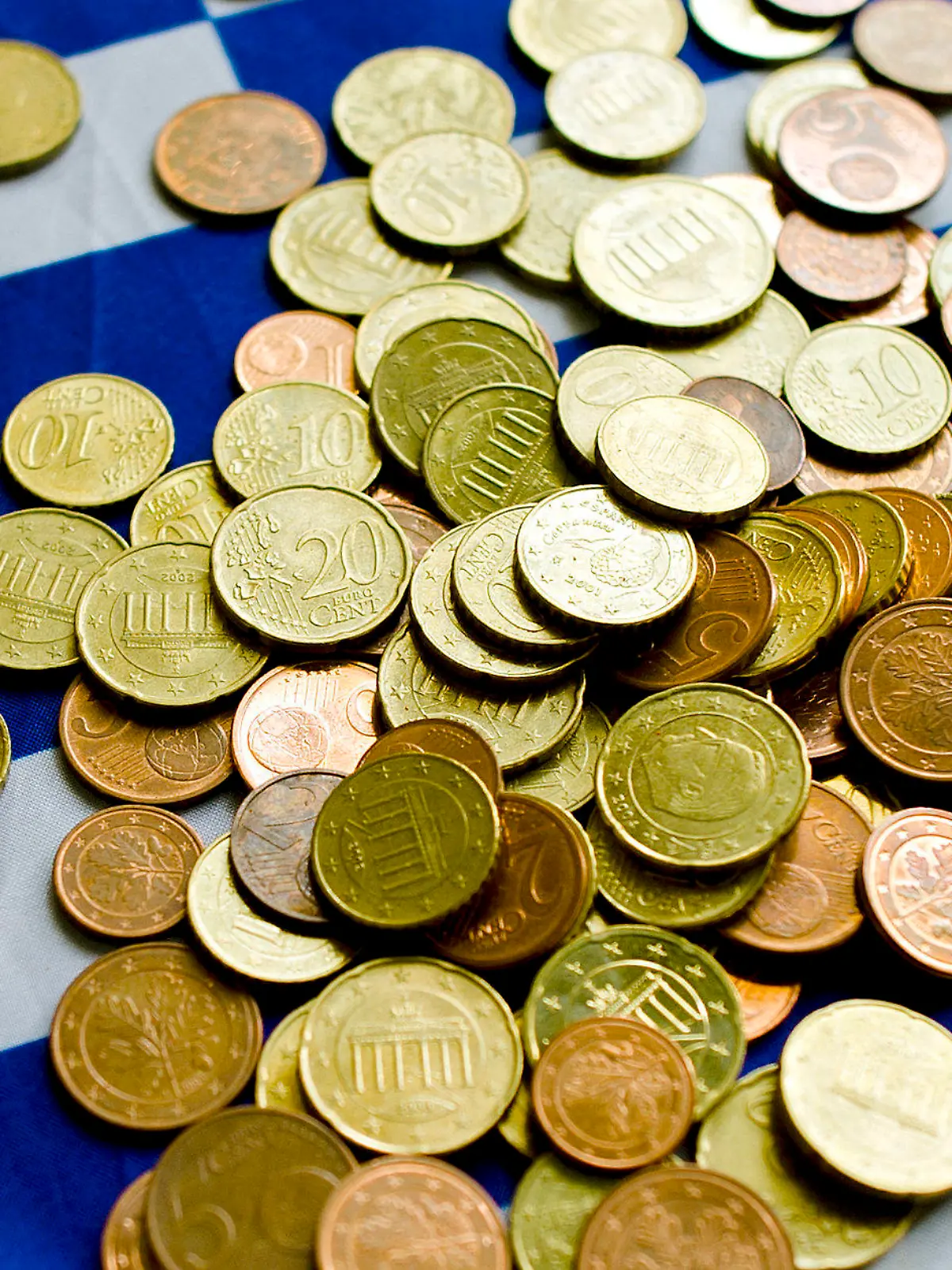 Illustration: Auf einer Griechenland-Fahne liegen Münzen, aufgenommen am Mittwoch (22.06.2011) in einem Griechischen Restaurant in Dresden. Der drohende Finanzkollaps in Griechenland wird zu Debatten der EU-Staats- und Regierungschefs bei ihrem am Donnerstagabend (23.06.2011) in Brüssel beginnenden Gipfeltreffen führen. Entscheidungen zu neuen Hilfen sind aber laut Einladungsschreiben nicht geplant. Foto: Arno Burgi dpa/lsn  +++(c) dpa - Bildfunk+++