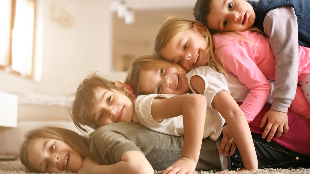 Large group of children lying at floor and having fun. Looking at camera.