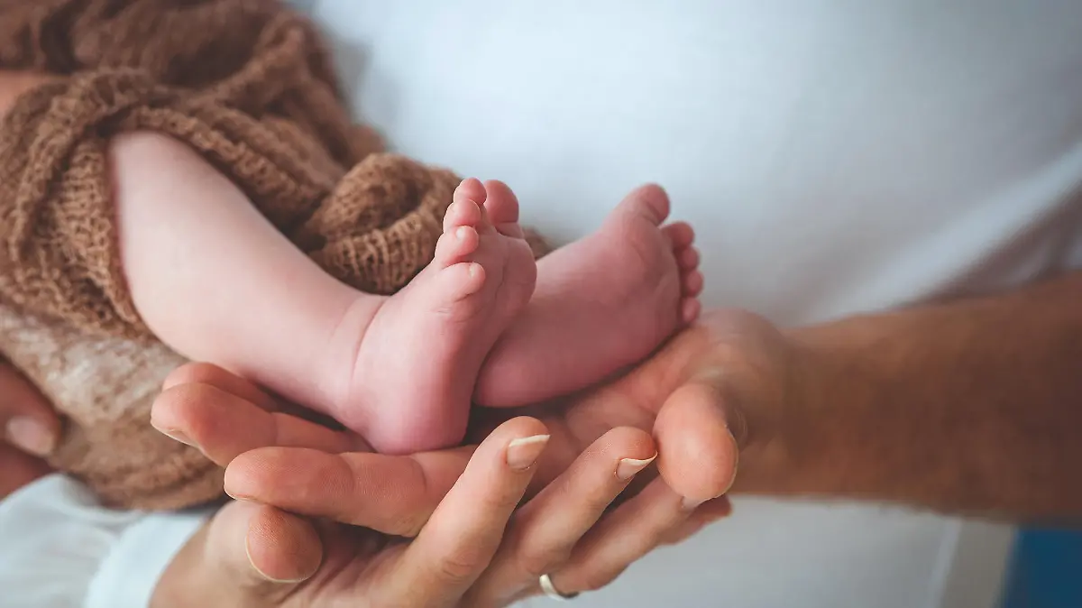 Mother and Father´s Hand Holding Baby´s Legs