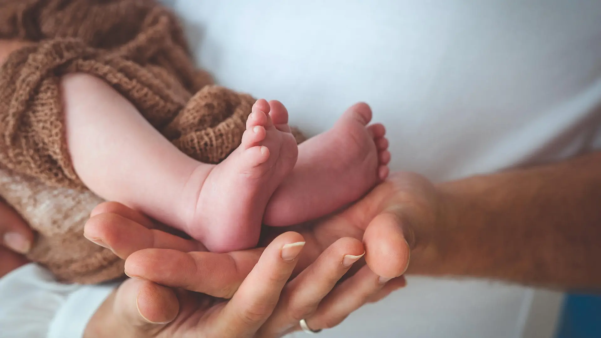 Mother and Father´s Hand Holding Baby´s Legs