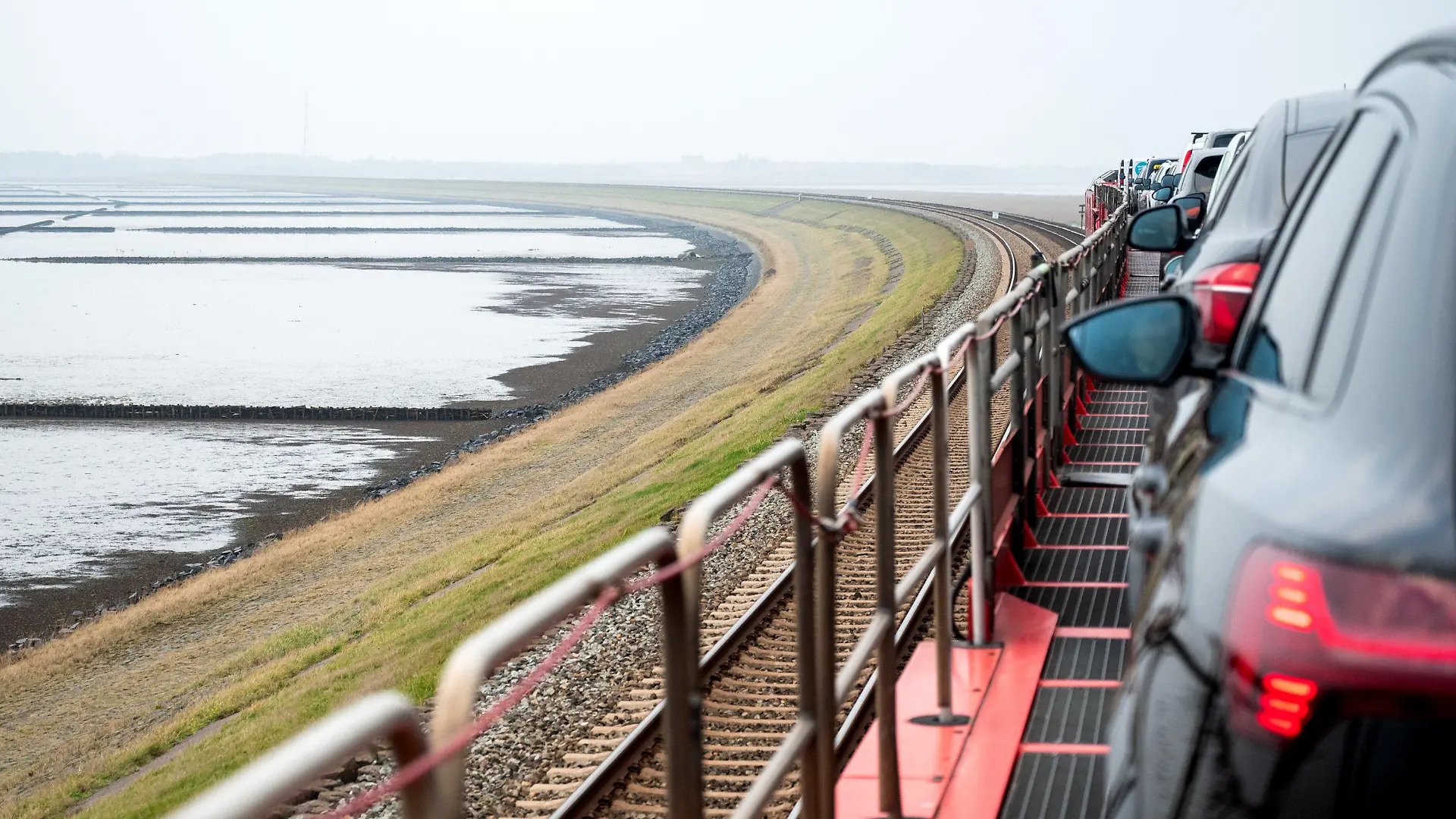 PRODUKTION - 30.11.2022, Schleswig-Holstein, Klanxbüll / Sylt: Ein Autozug der Deutschen Bahn fährt über den Hindenburgdamm auf die Nordseeinsel Sylt. In regelmäßigen Abständen flammt alle Jahre wieder die Debatte um eine Umbenennung des Bahndammes nach Sylt auf. (zu dpa ·Alle Jahre wieder - Vorstoß zur Umbenennung des Hindenburgdamms·`) Foto: Daniel Bockwoldt/dpa/Daniel Bockwoldt +++ dpa-Bildfunk +++