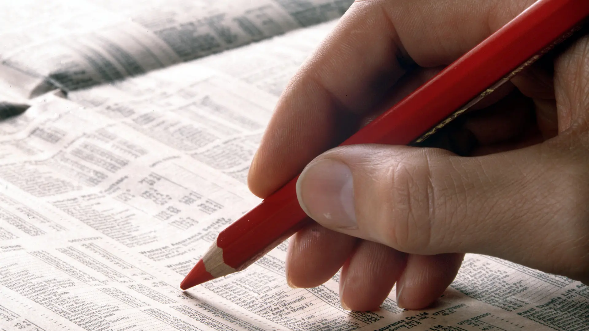 Eine Männerhand mit einem roten Stift geht die Aktiennotierungen im Börsenteil einer Zeitung durch. (Undatierte Aufnahme). Foto: Michael Rosenfeld +++(c) dpa - Report+++