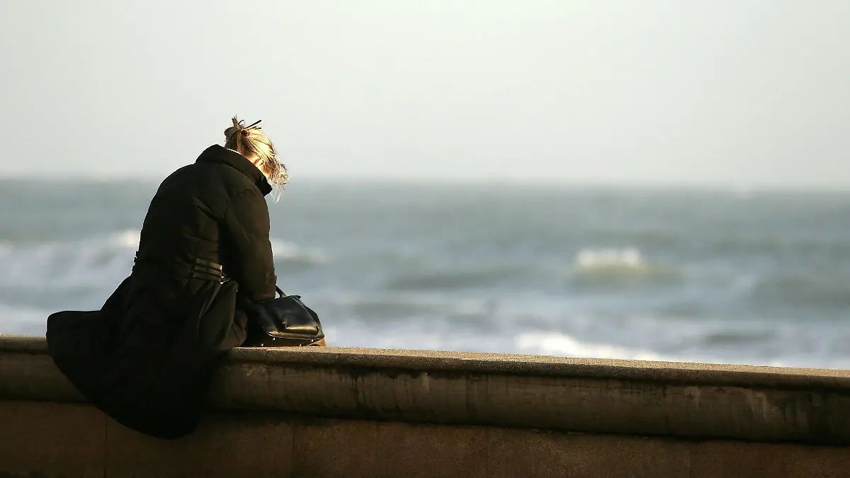 Eine junge Frau sitzt auf einer Mauer am Meer und blickt mit Selbstmordabsichten in den Abgrund. Gestellte Aufnahme zum Thema Selbstmord vom 07.10.2008. Foto: Franck Fouquet +++(c) dpa - Report+++