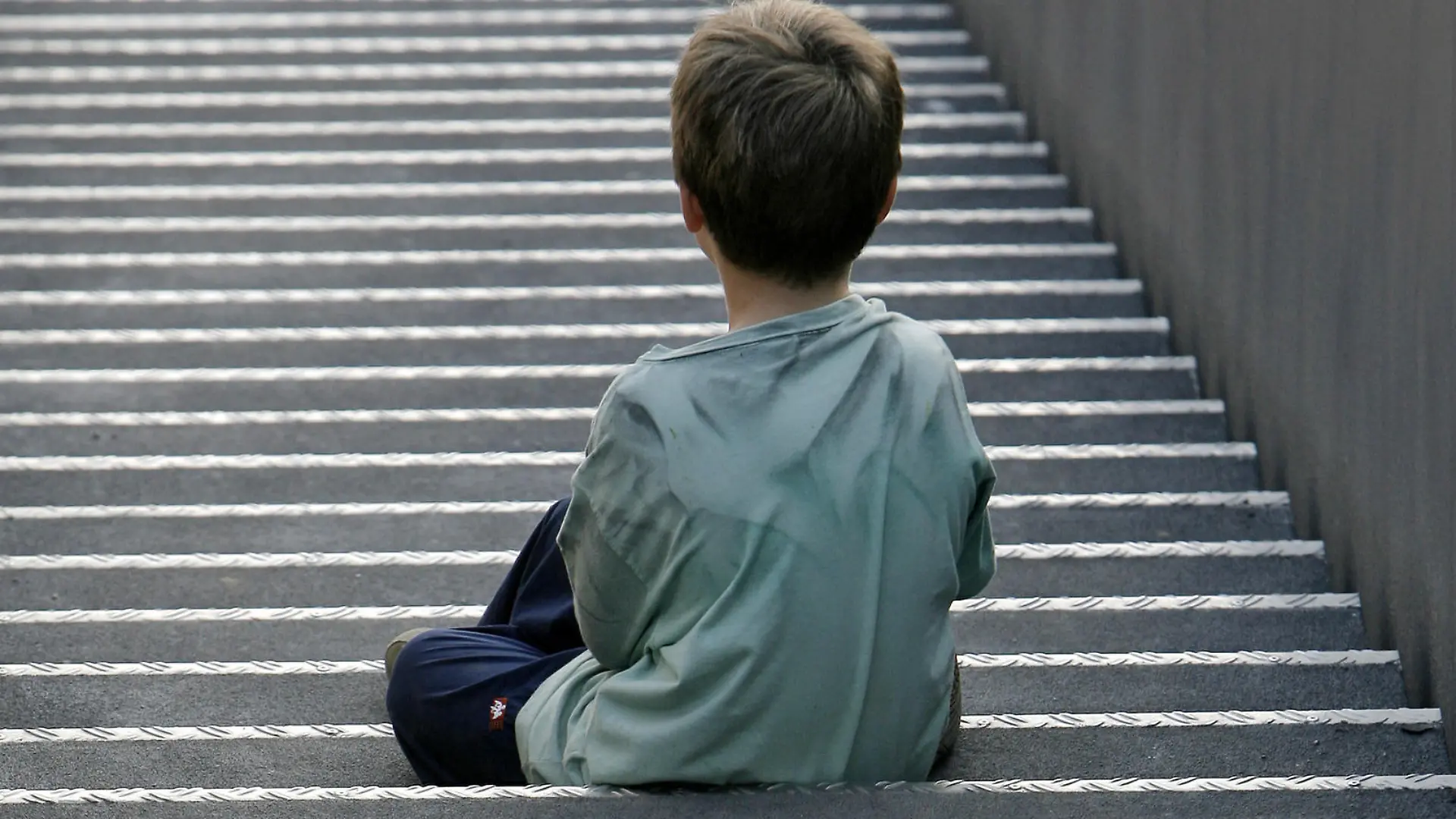 Ein kleiner Junge sitzt allein auf einer langen Treppe, aufgenommen am 23.09.2007 in Neukirchen-Vluyn. Foto: Arno Burgi  +++(c) dpa - Report+++