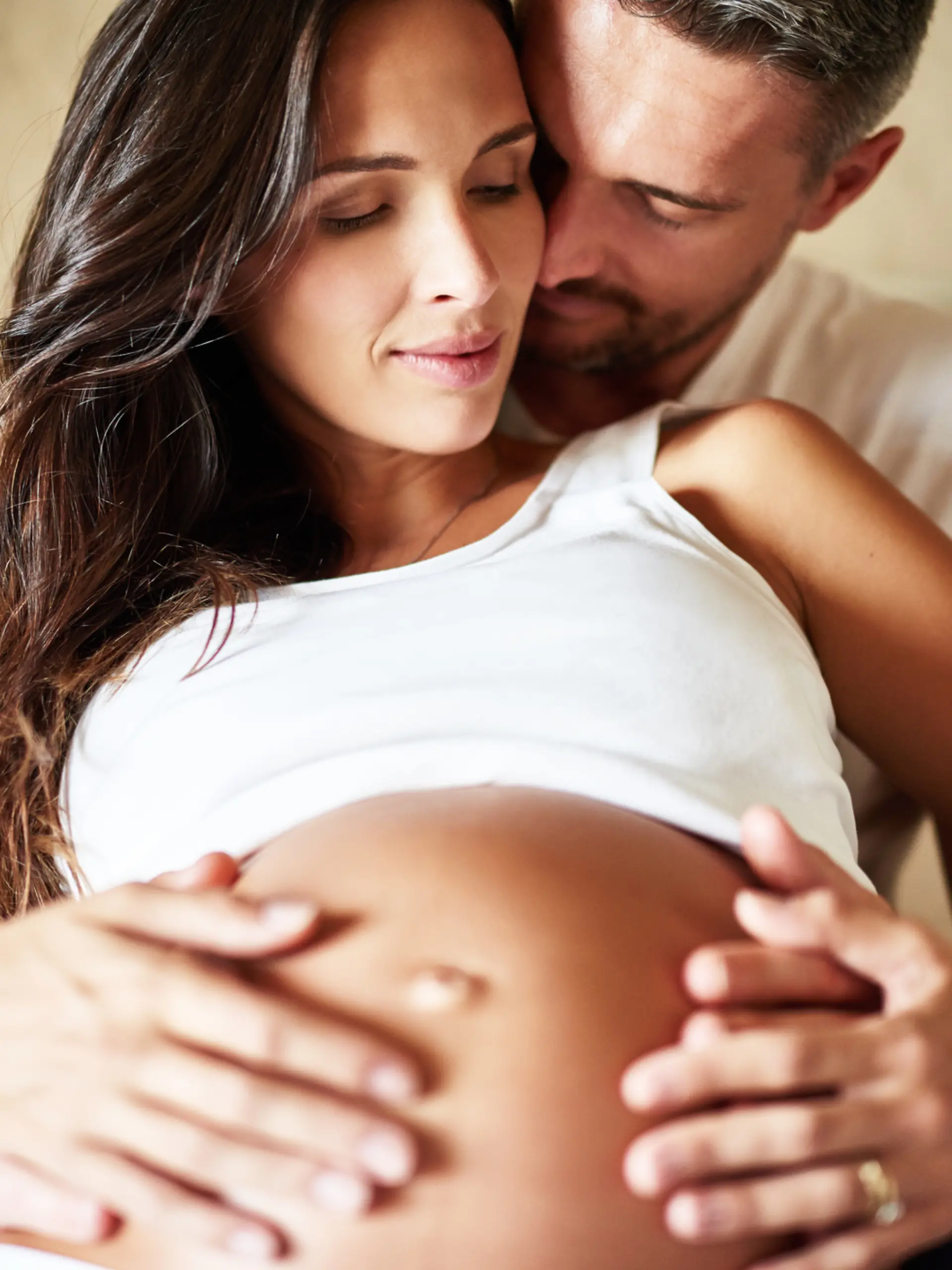 Shot of a husband and pregnant wife sitting together in a bedroom