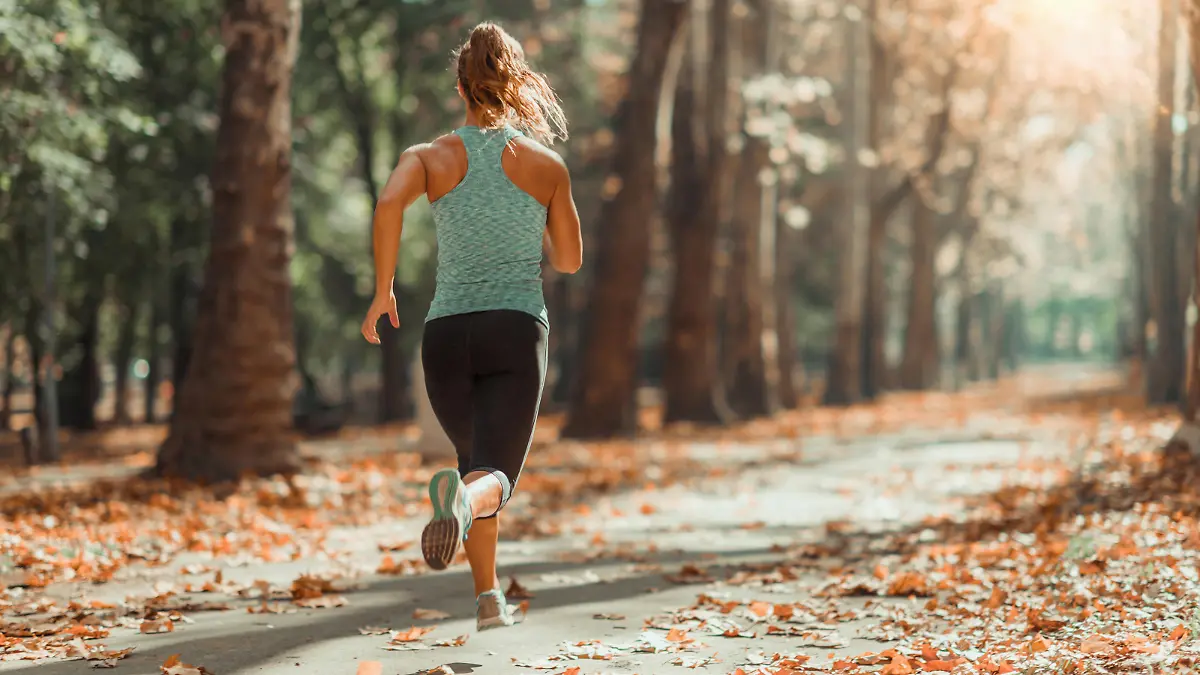 Woman Jogging Outdoors In Autumn in Public Park