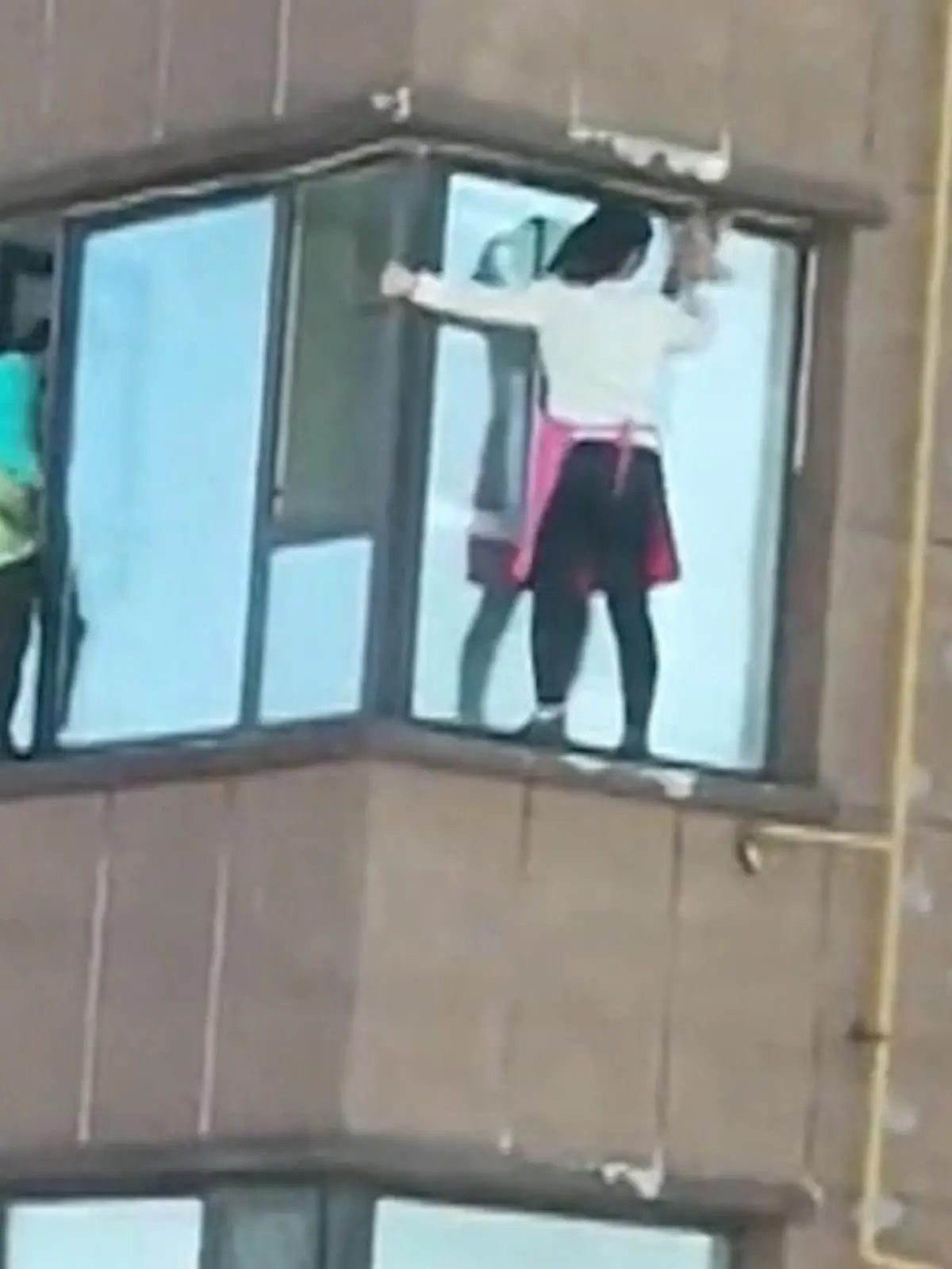 In der chinesischen Provinz Jilin putzen zwei Frauen in schwindelerregender Höhe die Fenster eines Hochhauses.