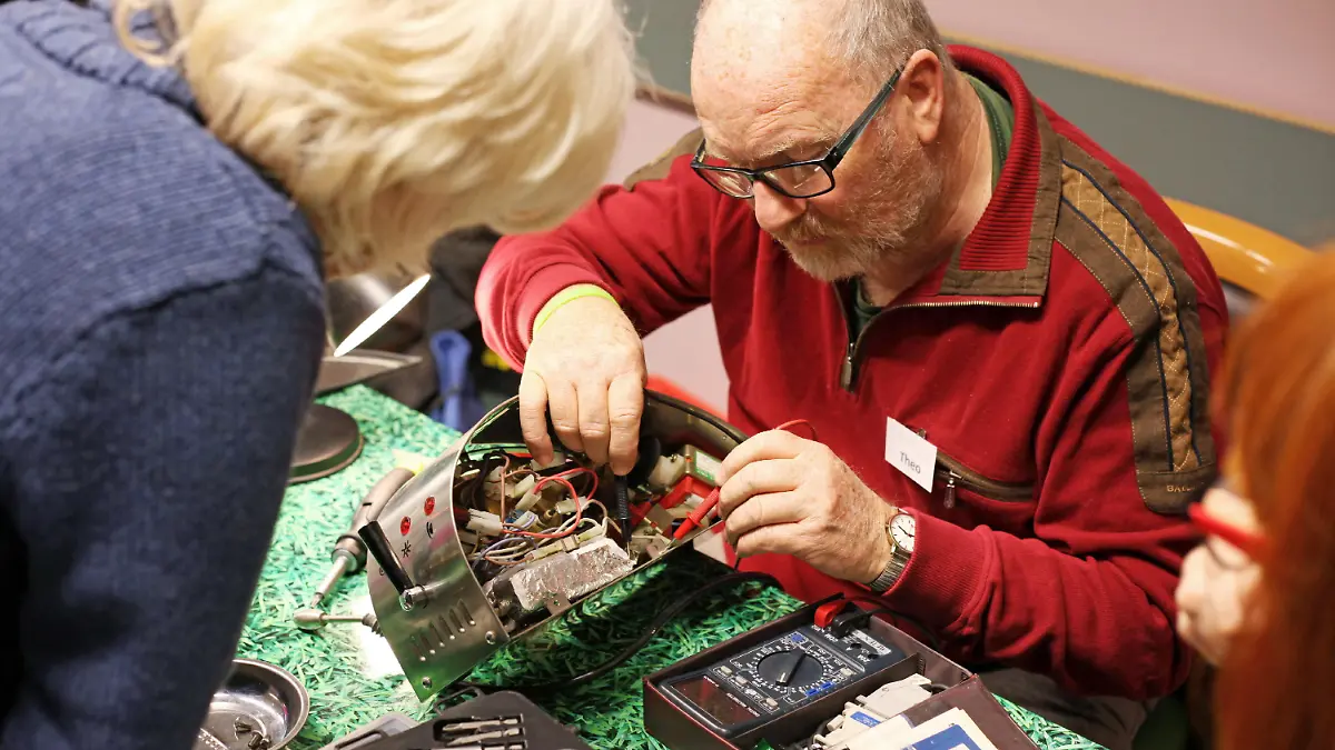 Repair-Cafe, Amsterdam. Hier reparieren vor allem Rentner kostenlos kaputte ElektrogerÃ_te und Elektronikprodukte. Sie retten so alte GerÃ_te vor der Verschrottung. Die Zielsetzung des Projektes richtet sich gegen die Wegwerfgesellschaft und will so etwas gegen den Resourcenverbrauch und fÃ_r den Umweltschutz erreichen. Das Projekt finanziert sich durch Spenden. Hier: der ehemalige Techniker und nun RuhestÃ_ndler Theo repariert eine Espressomaschine im Repair-Cafe in seiner Freizeit. Amsterdam, Niederlande, 23.03.2012