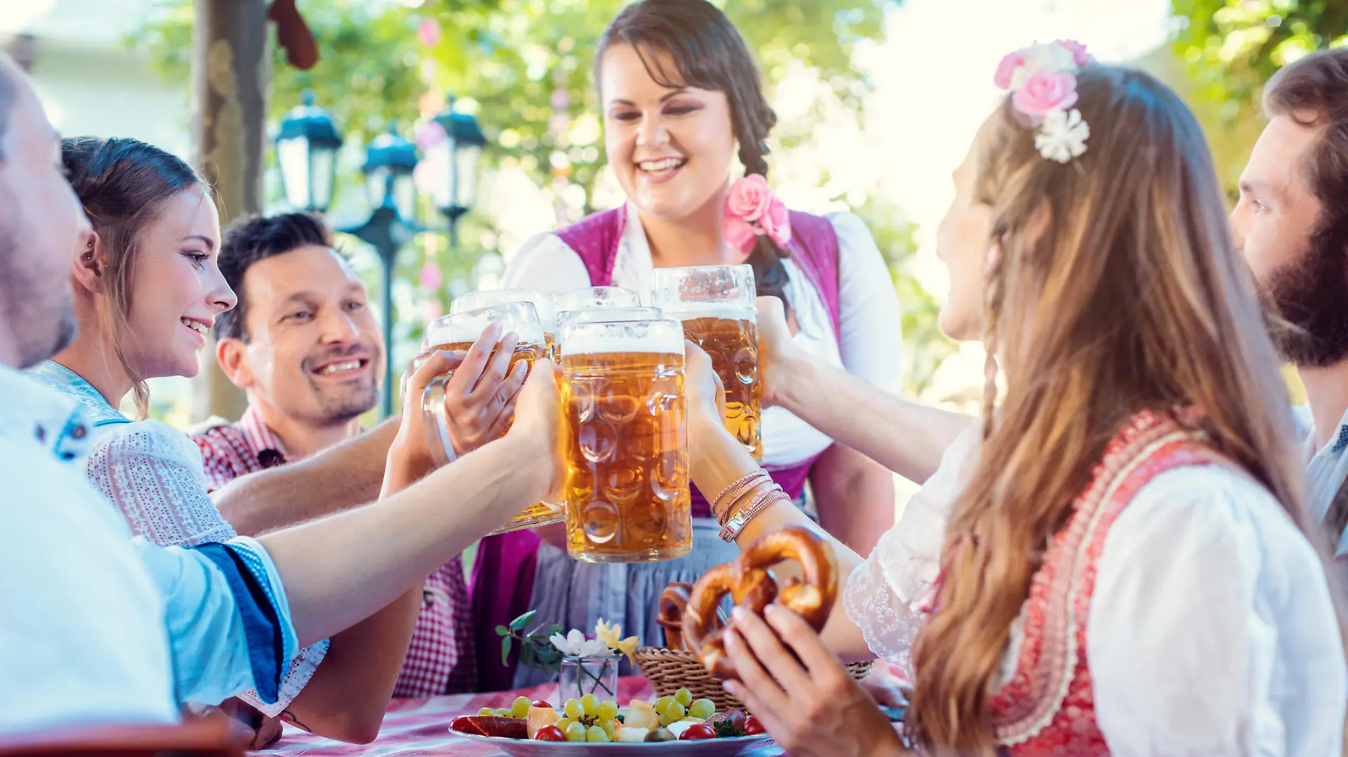 Cheerful group of friends toasting in Bavarian beer garden