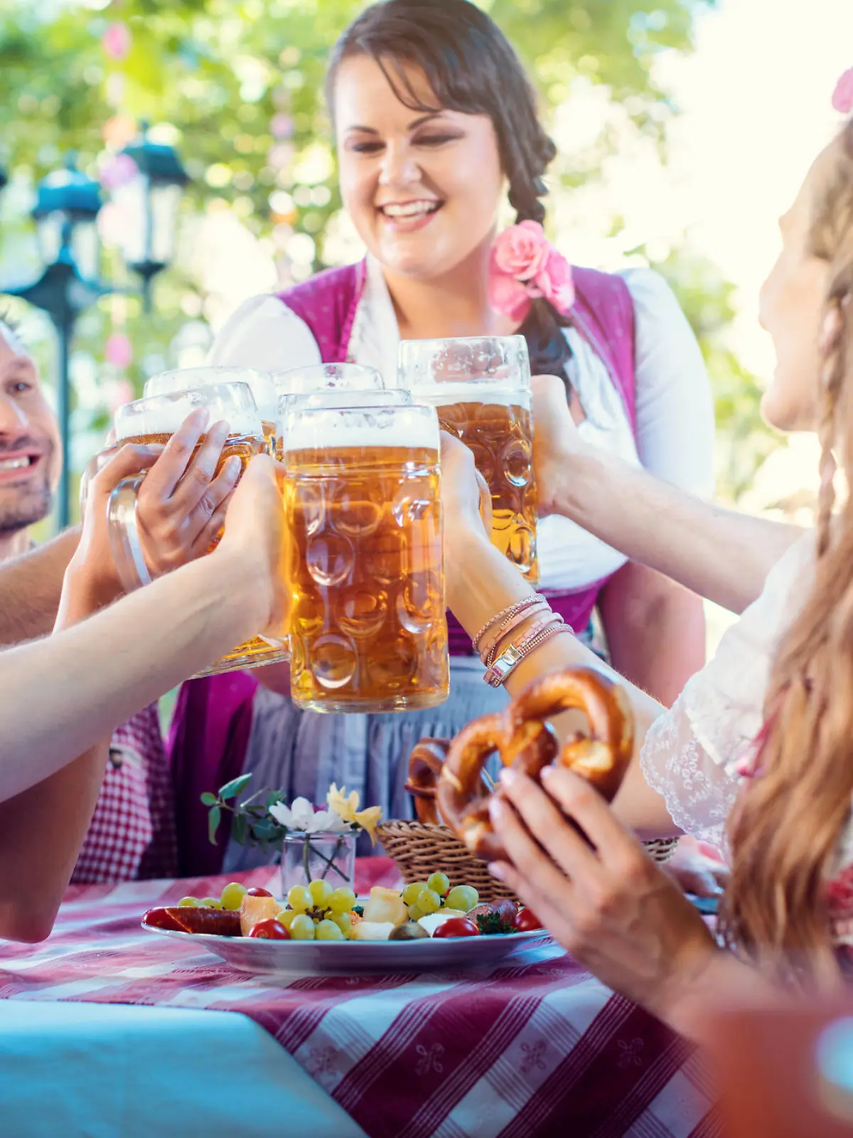 Cheerful group of friends toasting in Bavarian beer garden
