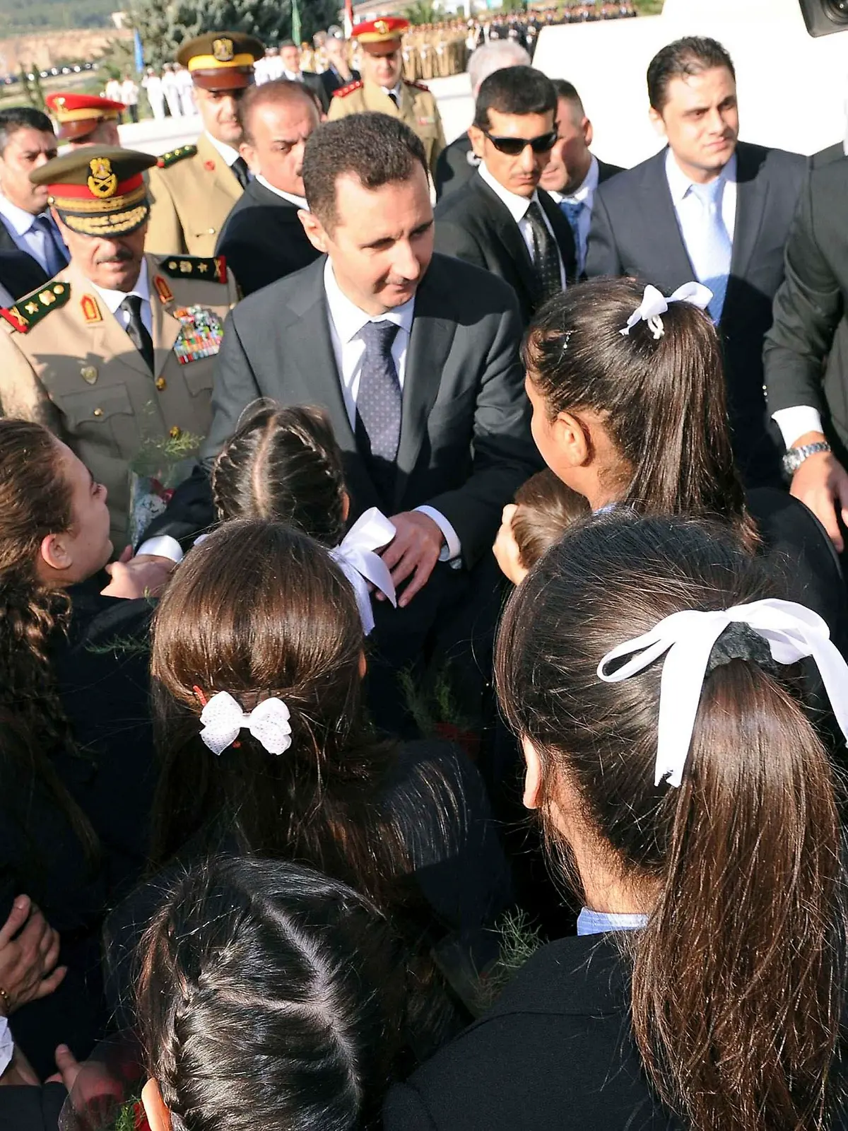 Syria's President Bashar al-Assad (C) talks to the children of soldiers who have died while fighting in wars, after placing flowers at the Tomb of the Unknown Soldier during a ceremony to mark the 39th anniversary of the 1973 October War with Israel, in Damascus, in this October 6, 2012 handout photograph released by Syria's national news agency SANA. REUTERS/SANA (SYRIA - Tags: ANNIVERSARY CONFLICT MILITARY POLITICS) FOR EDITORIAL USE ONLY. NOT FOR SALE FOR MARKETING OR ADVERTISING CAMPAIGNS. THIS IMAGE HAS BEEN SUPPLIED BY A THIRD PARTY. IT IS DISTRIBUTED, EXACTLY AS RECEIVED BY REUTERS, AS A SERVICE TO CLIENTS
