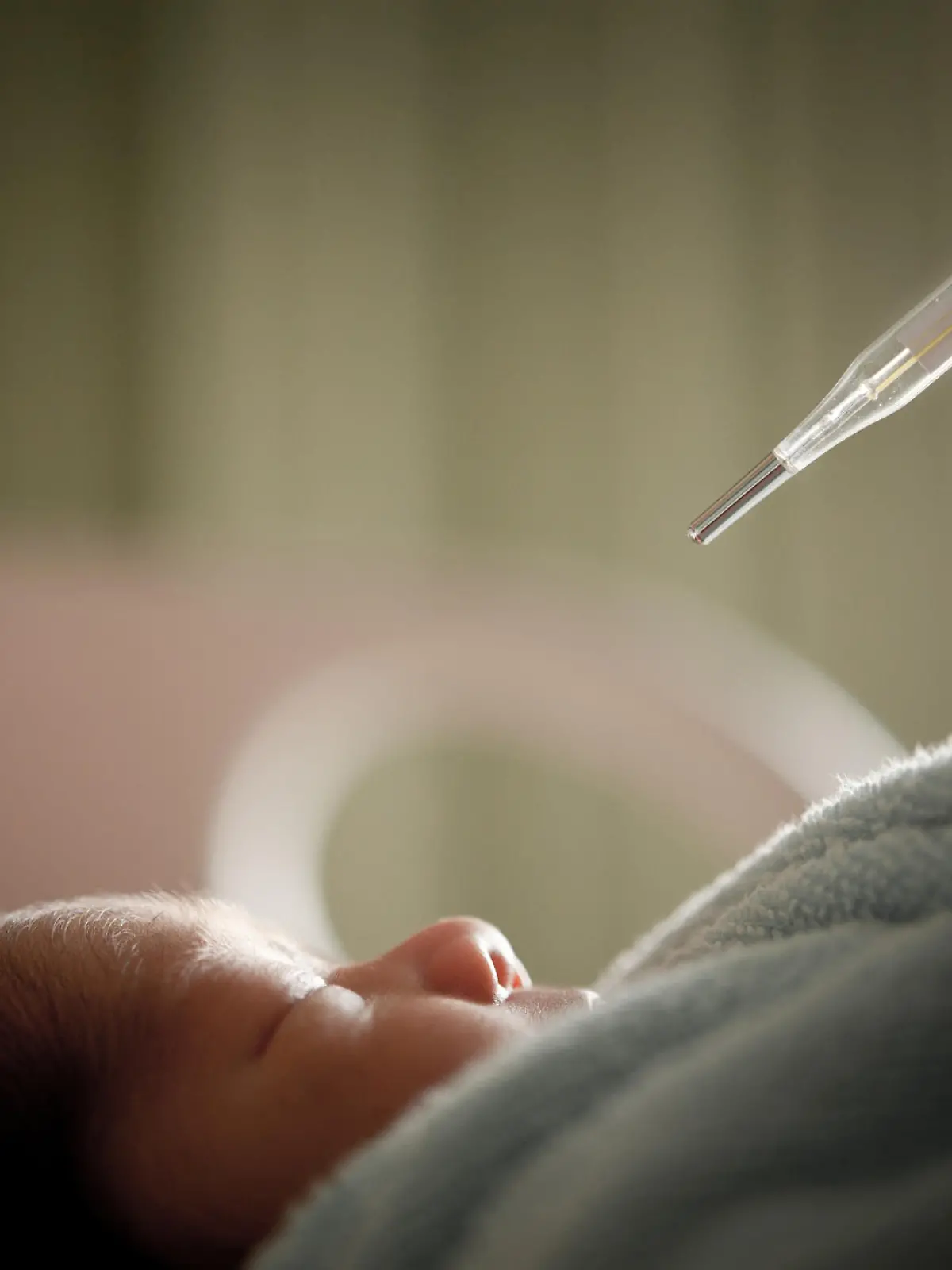 Doctor checking baby's temperature.