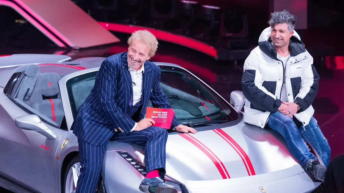11.12.2022, Nordrhein-Westfalen, Hürth: Thomas Gottschalk (l), Moderator, und  Lotto-Millionär Kürsat Yildirim alias "Chico" sitzen auf einem Ferrari beim RTL-Jahresrückblick "Menschen, Bilder, Emotionen 2022" im Studio. Foto: Rolf Vennenbernd/dpa +++ dpa-Bildfunk +++