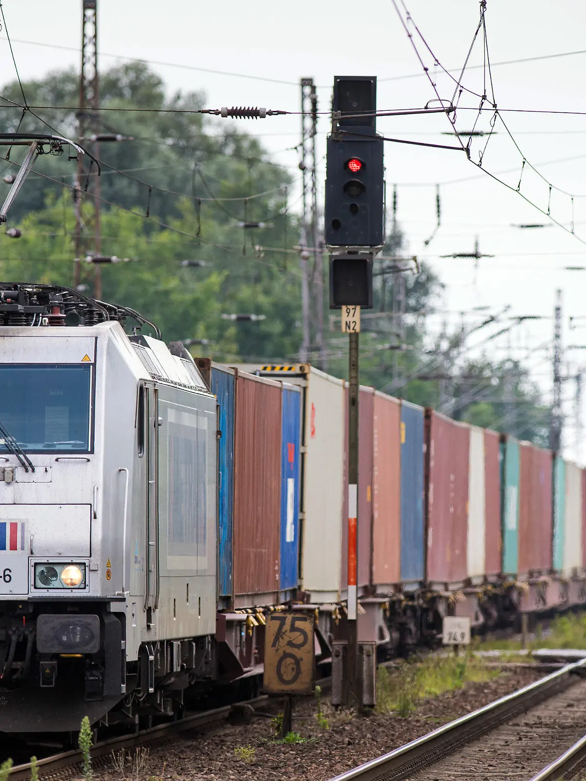 ARCHIV - 10.08.2020, Brandenburg, Wustermark: Ein von einer E-Lok der Hamburger Hafen und Logistik AG (HHLA) gezogener Güterzug passiert den Bahnhof des Dorfes Priort in der Gemeinde Wustermark. Der Interessenverband Allianz pro Schiene mahnt mehr Tempo bei der Elektrifzierung von Gleisstrecken in Deutschland an. (Zu dpa "chienenverband fordert mehr Tempo bei Elektrifizierung") Foto: Soeren Stache/dpa-Zentralbild/dpa +++ dpa-Bildfunk +++