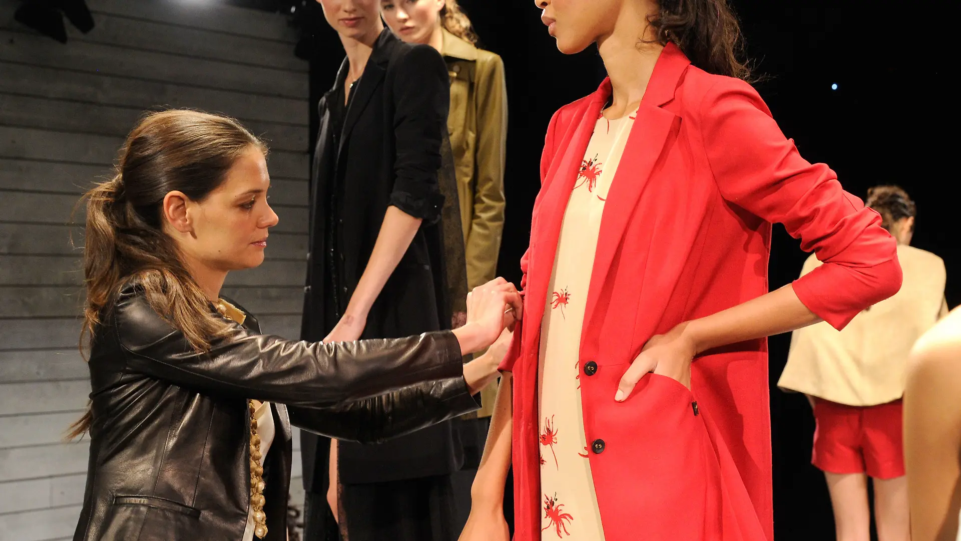 NEW YORK, NY - SEPTEMBER 12: Katie Holmes makes adjustments with model during rehearsals for the Holmes & Yang presentation during Spring 2013 Mercedes-Benz Fashion Week at The Box at Lincoln Center on September 12, 2012 in New York City. (Photo by Kevin Mazur/Getty Images)