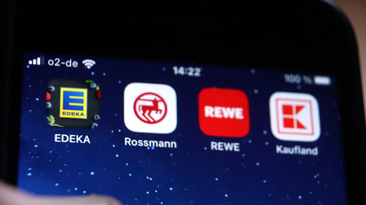 ILLUSTRATION - 02.12.2022, Bayern, Kaufbeuren: Icons der Apps von den Handelsketten Edeka (l-r), Rossmann, REWE und Kaufland sind auf dem Display eines iPhones zu sehen. Wer angesichts der Inflation beim Einkaufen die besten Angebote nutzen will, braucht in immer mehr Geschäften eine zusätzliche App. (zu dpa «Verbraucherschützerin: Nutzer bezahlen Spar-Apps mit Daten») Foto: Karl-Josef Hildenbrand/dpa +++ dpa-Bildfunk +++