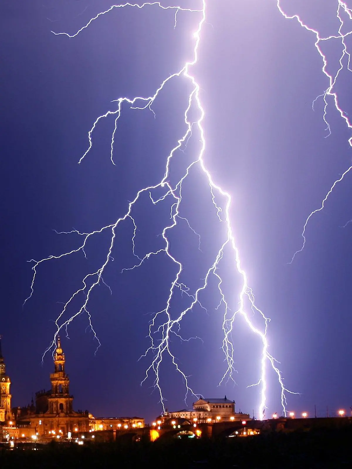 Ein Blitz entlädt sich Montagnacht (16.07.2007) während eines Gewitters über der historischen Alstadt von Dresden mit Hausmannsturm, Hofkirche und Semperoper (l-r). Das hochsommerliche Wetter soll voraussichtlich nur noch bis Donnerstag anhalten. Foto: Ralf Hirschberger dpa/lsn +++(c) dpa - Bildfunk+++