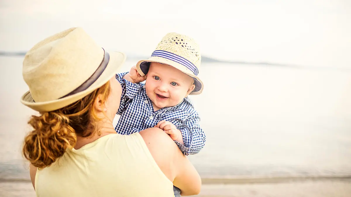 Mom with cute baby on the beach