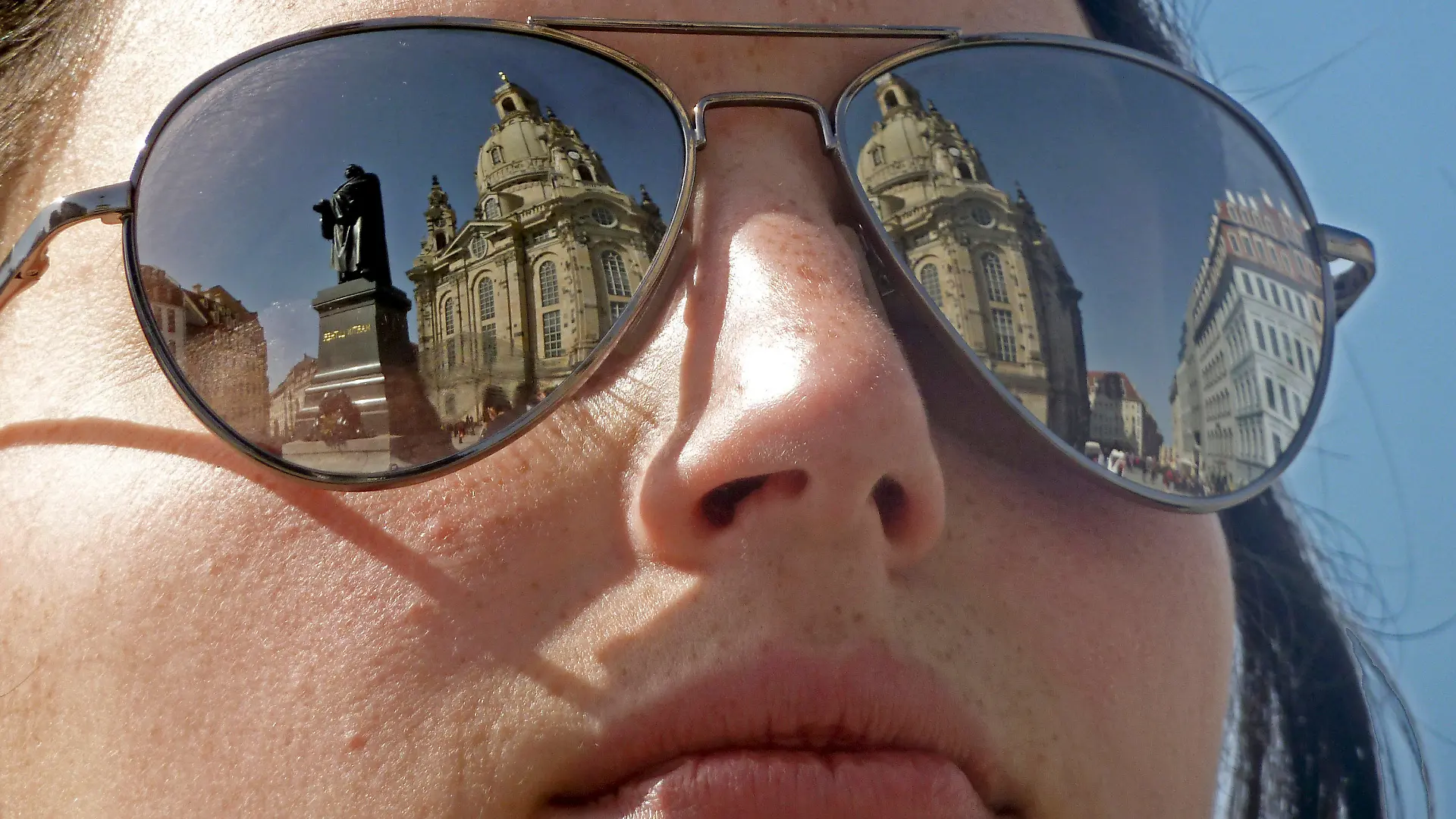 In der Sonnenbrille einer Frau spiegelen sich am Sonntag (10.04.2011) in Dresden das Martin Luther Denkmal und die Dresdner Frauenkirche. Die Tageshöchstwerte liegen in der sächsischen Landeshauptstadt bei bis zu 17 Grad. Foto: Robert Schlesinger lsn +++(c) dpa - Bildfunk+++