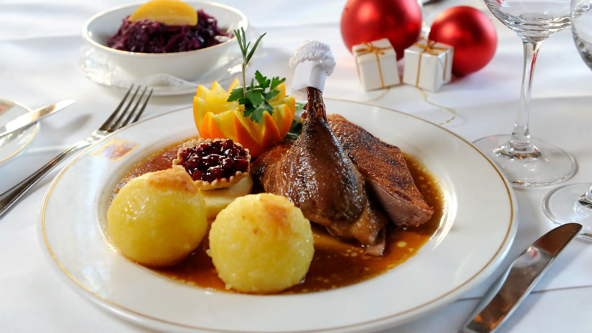 ARCHIV - 30.11.2010, Bayern, München: Eine 1/4 Gans mit Knödeln und Rotkohl steht auf einem gedeckten Tisch. (zu dpa: «Weihnachtsgerichte mit Geschichte: Die Sehnsucht an der Festtagstafel») Foto: Tobias Hase/dpa +++ dpa-Bildfunk +++