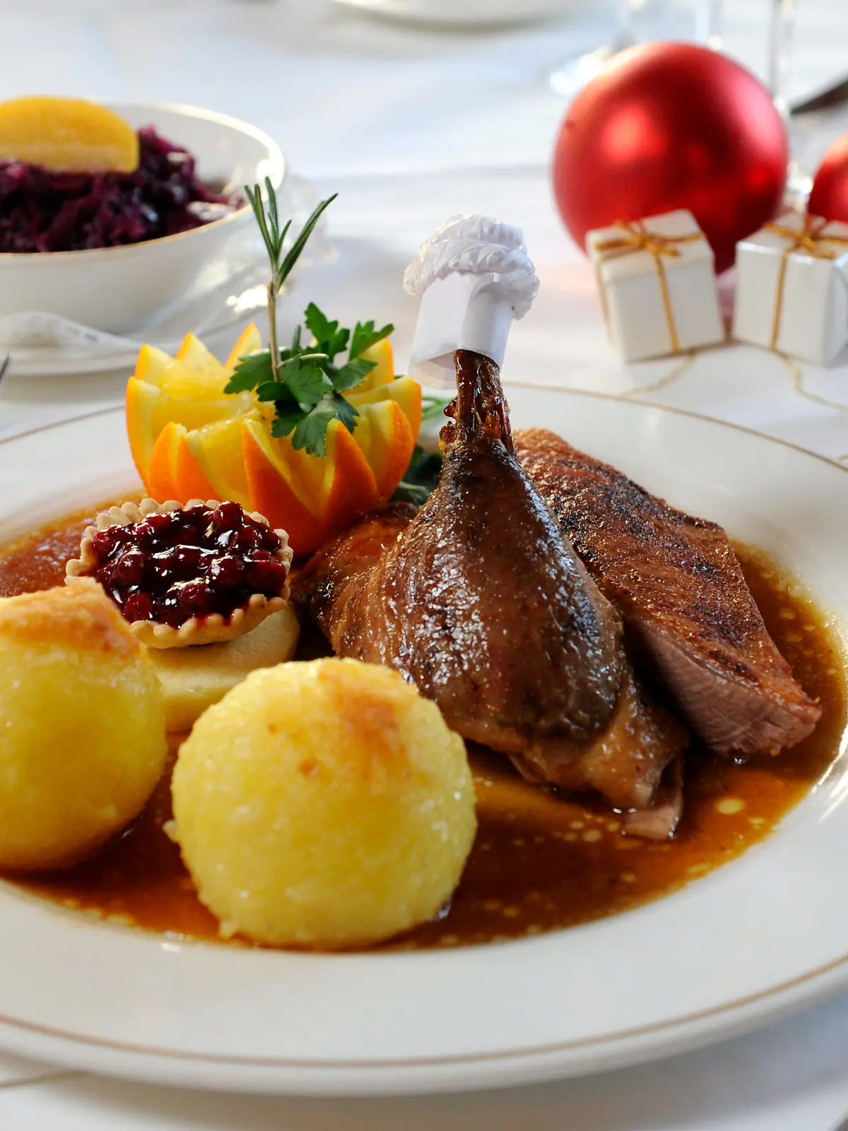 ARCHIV - 30.11.2010, Bayern, München: Eine 1/4 Gans mit Knödeln und Rotkohl steht auf einem gedeckten Tisch.  (zu dpa: «Weihnachtsgerichte mit Geschichte: Die Sehnsucht an der Festtagstafel») Foto: Tobias Hase/dpa +++ dpa-Bildfunk +++