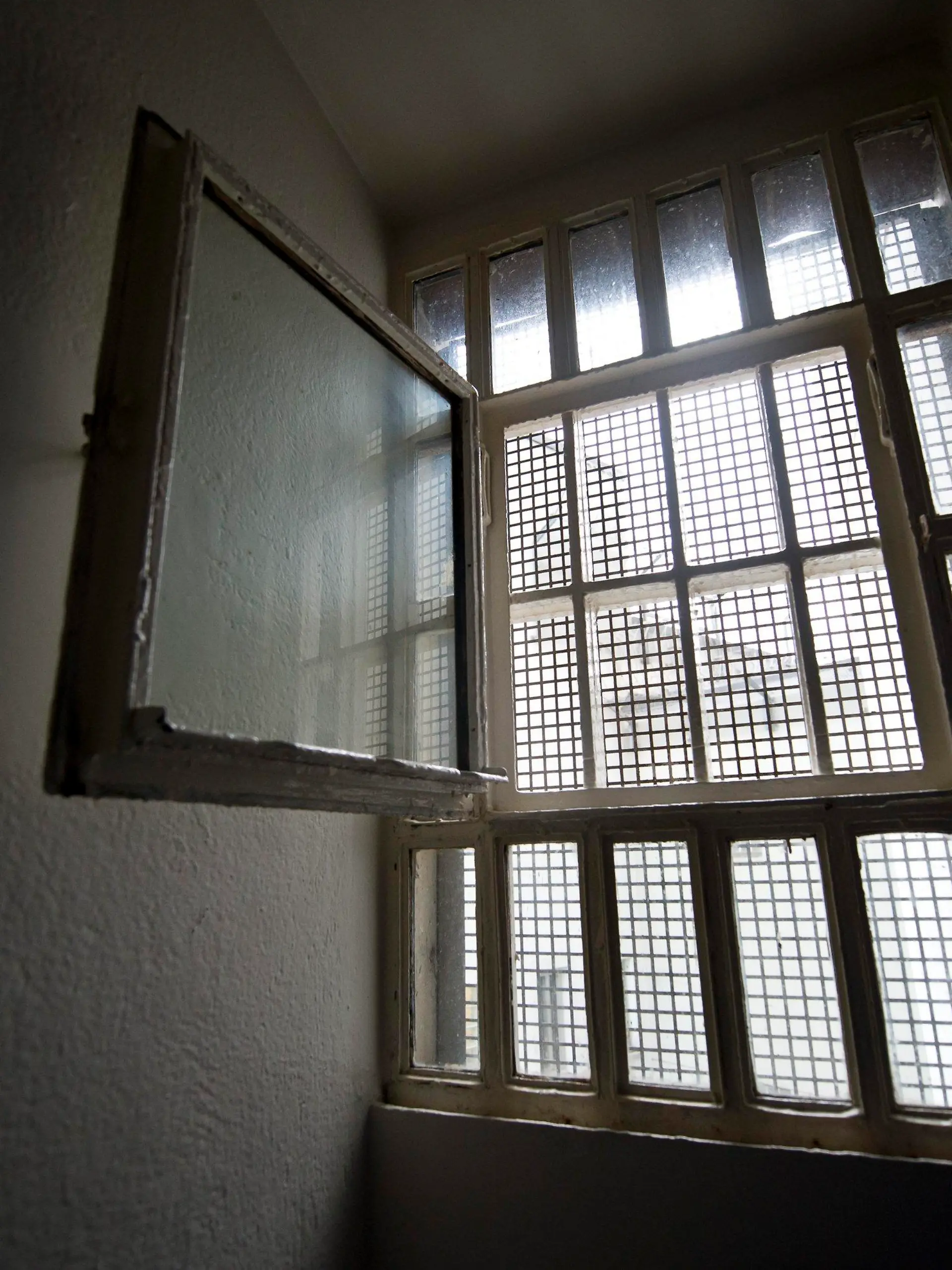 ARCHIV - Ein Fenster, hinter dem ein Gitter befestigt ist, ist am 21.11.2014 in der Justizvollzugsanstalt in Stuttgart (Baden-Württemberg) in einer Gefängniszelle zu sehen. In 2014 wurden in Niedersachsen laut dem Justizministerium 111 Jugendliche zur Abschreckung vor einer kriminellen Zukunft für bis zu vier Wochen hinter Gitter geschickt. Foto: Daniel Naupold/dpa (zu lni «Niedersachsens Richter verhängen immer häufiger den Warnschussarrest» vom 14.04.2015) +++(c) dpa - Bildfunk+++